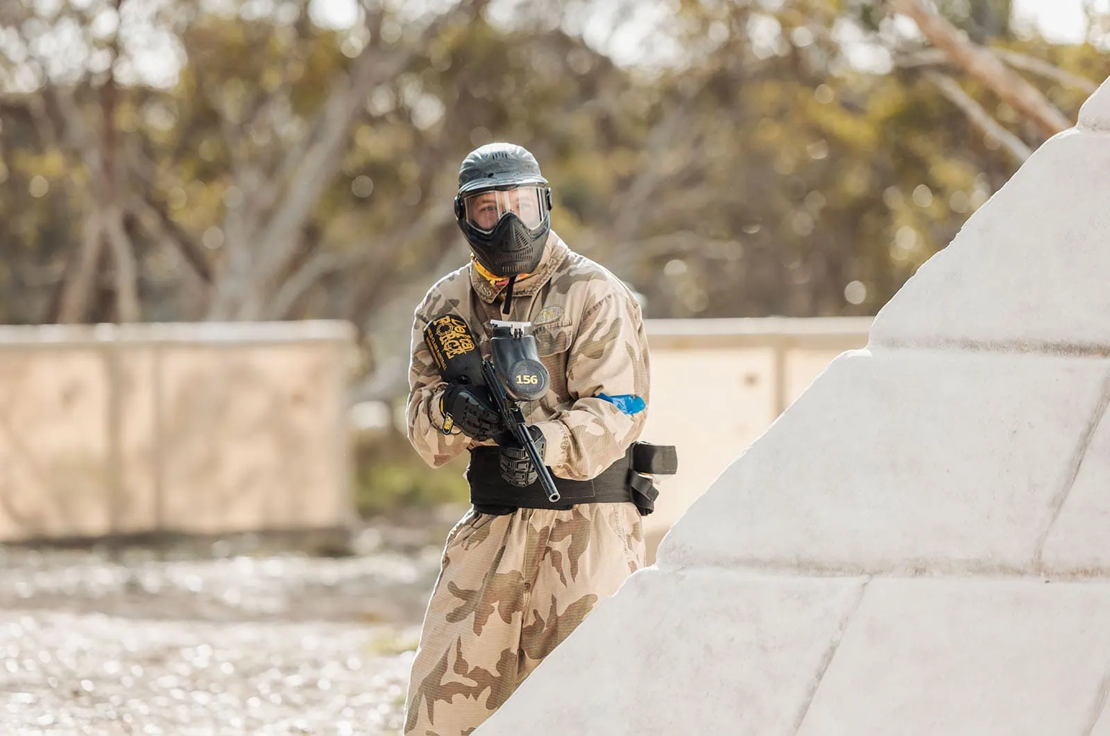 monarto delta force bucks vs hens paintball party 13 Paintball player in camouflage gear taking cover in outdoor game.