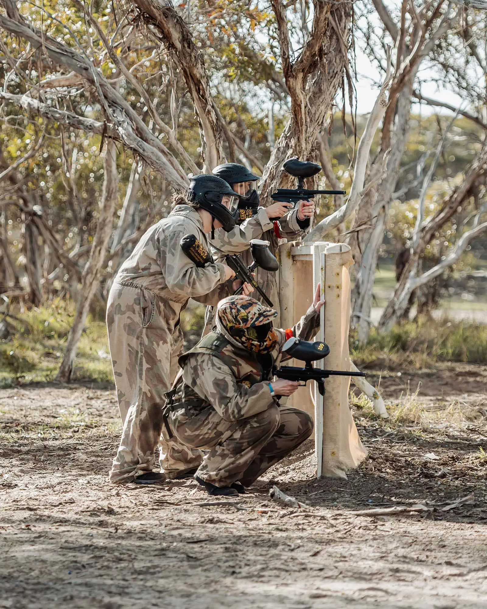 monarto delta force bucks vs hens paintball party 21 Paintball players in camouflage gear engaging in a wooded combat scenario.