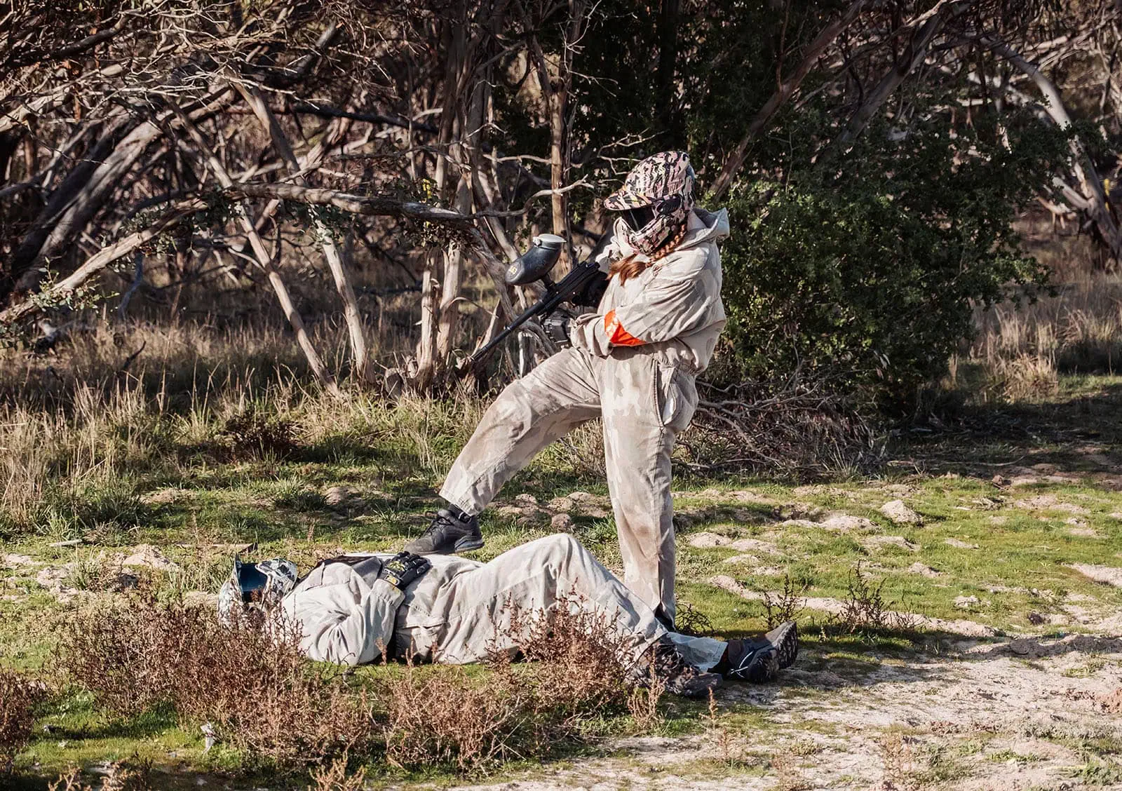 monarto delta force bucks vs hens paintball party 24 Paintball game in forest, player standing victorious over defeated opponent.