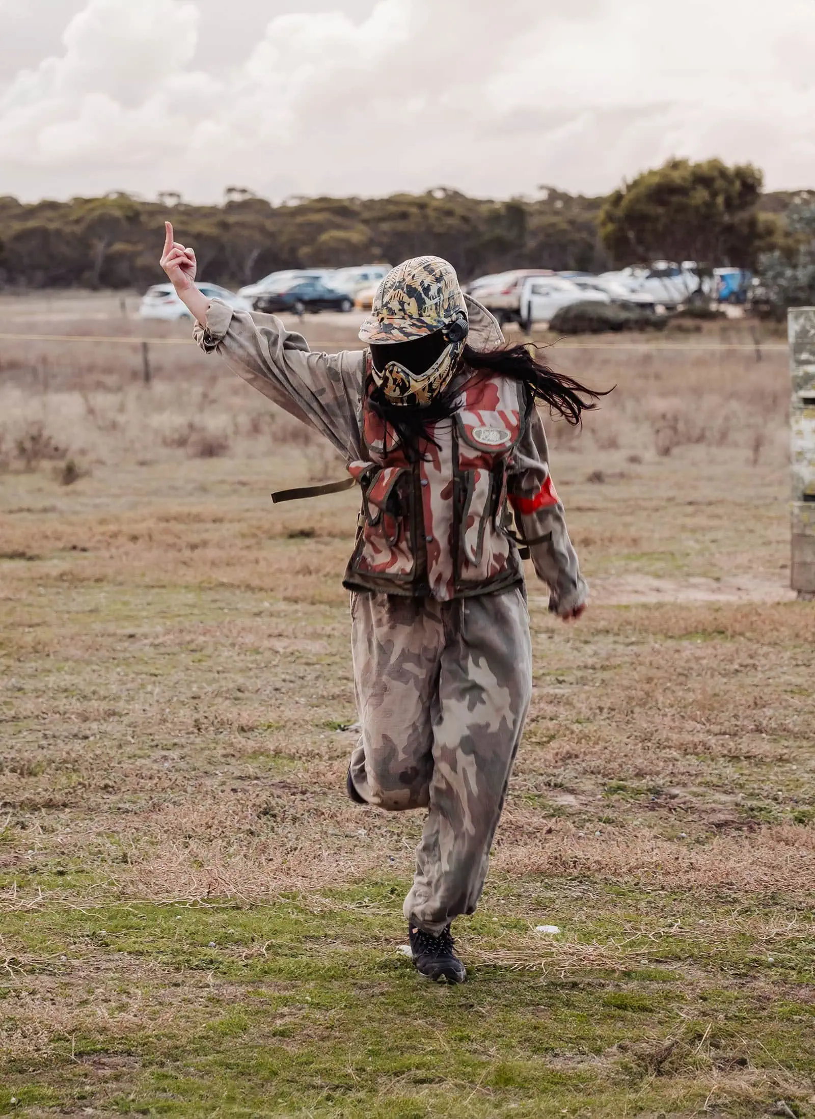 monarto delta force bucks vs hens paintball party 39 Paintball player in camouflage running and gesturing in an outdoor field.