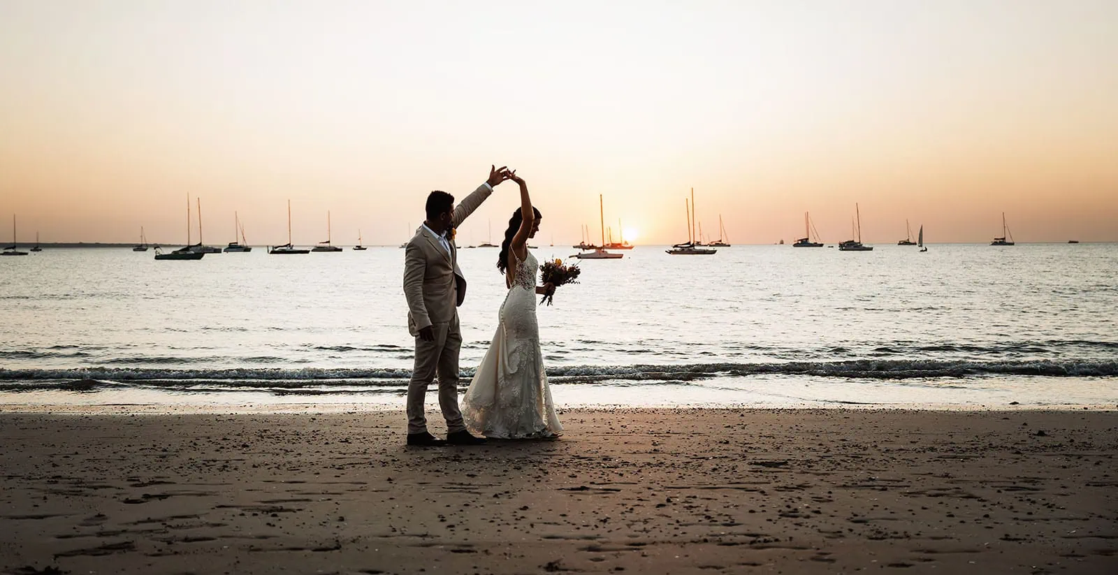 the best darwin wedding venues 2 Tropical sunset gathering with elegant decor, festoon lights, and guests mingling by the ocean.