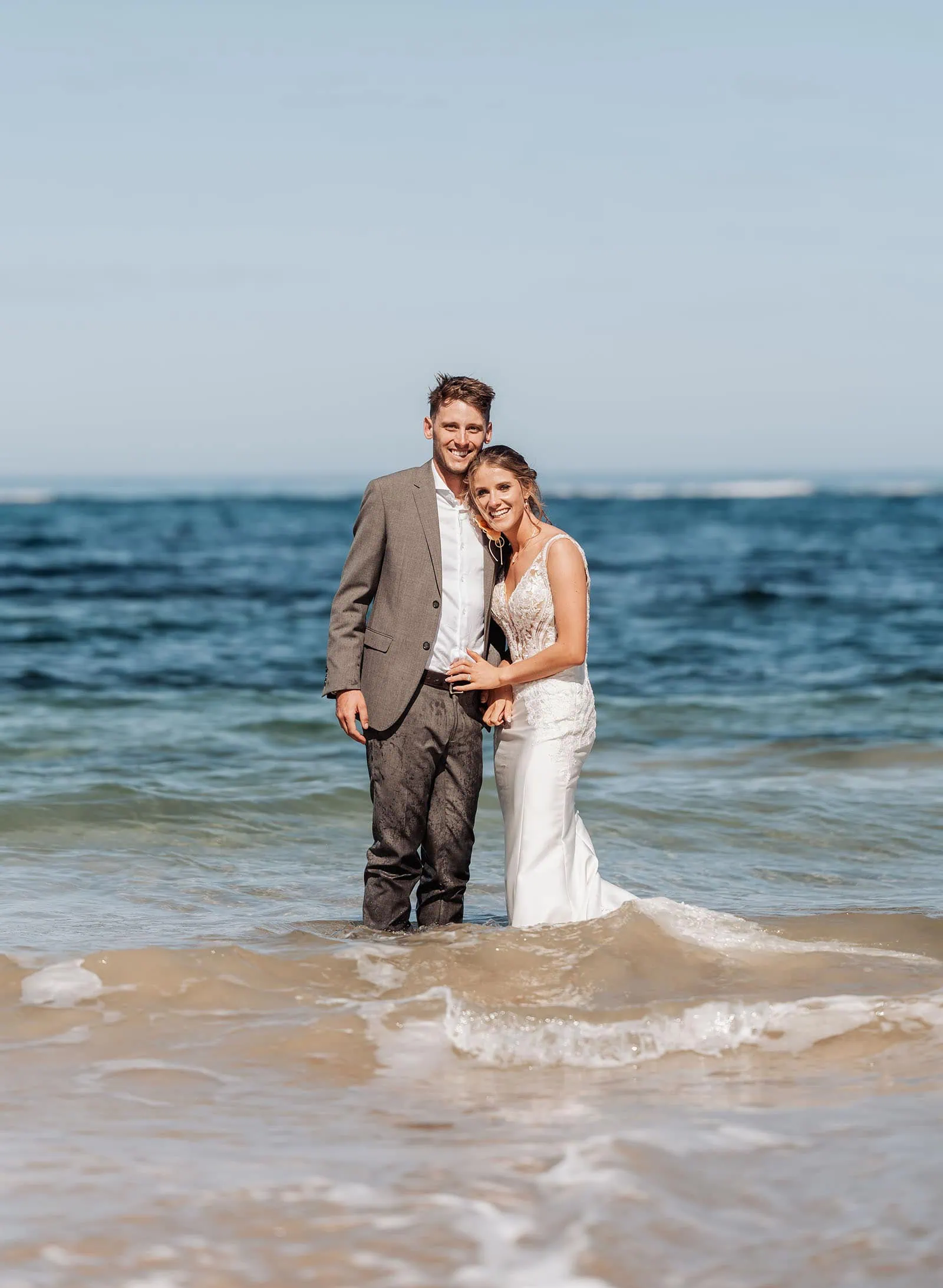pt noarlunga underwater wreck the dress shoot - jess & jack 5 Joyful couple at oceans edge in formal attire, celebrating love on a sunny beach.