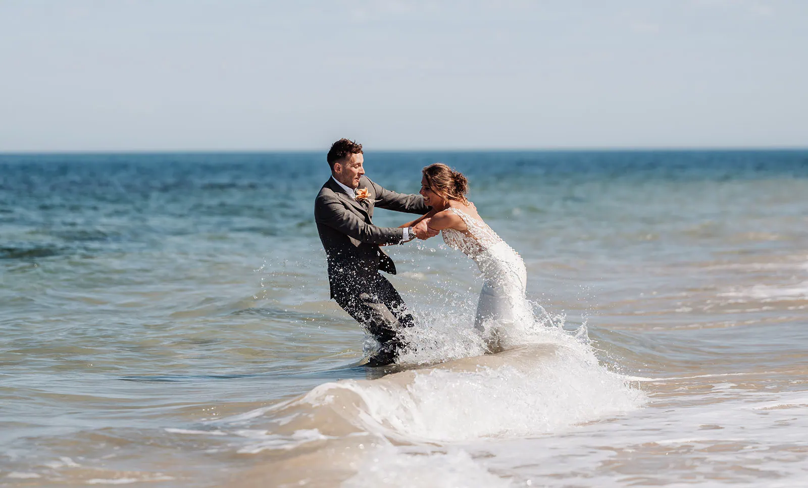 pt noarlunga underwater wreck the dress shoot - jess & jack 8 Couple in wedding attire joyfully playing in ocean waves at a scenic beach.
