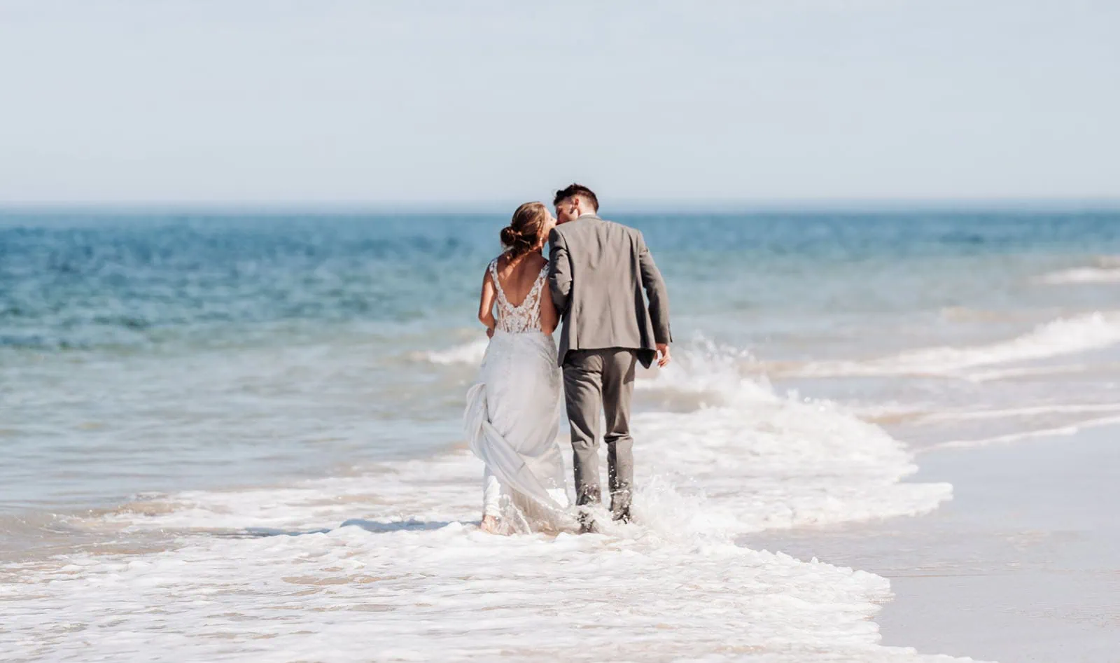 pt noarlunga underwater wreck the dress shoot - jess & jack 3 Romantic couple in wedding attire walking along a serene beach at sunset.