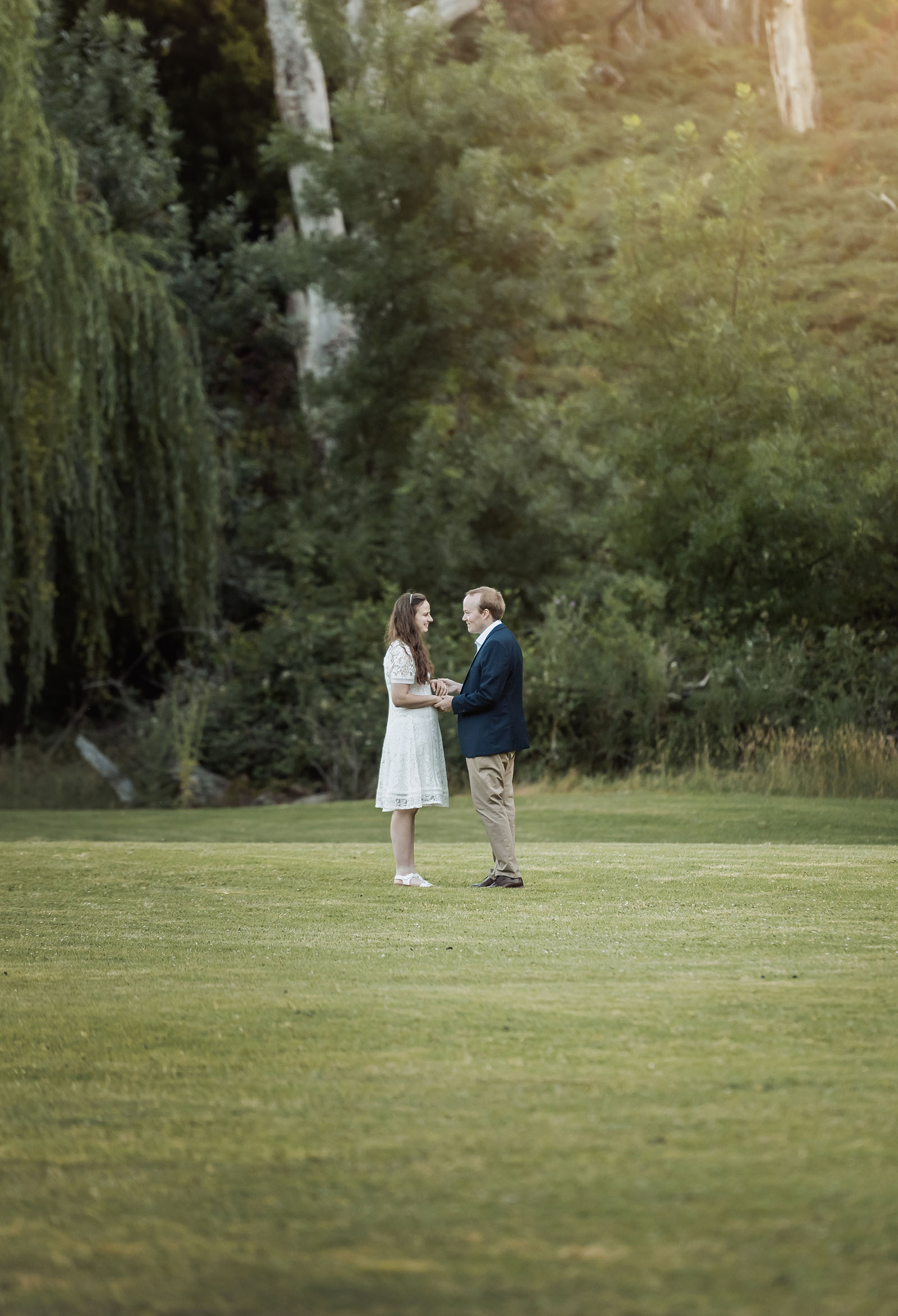 romantic belair national park proposal - marissa & james 138 Marissa and James holding hands on a grassy clearing at Belair National Park