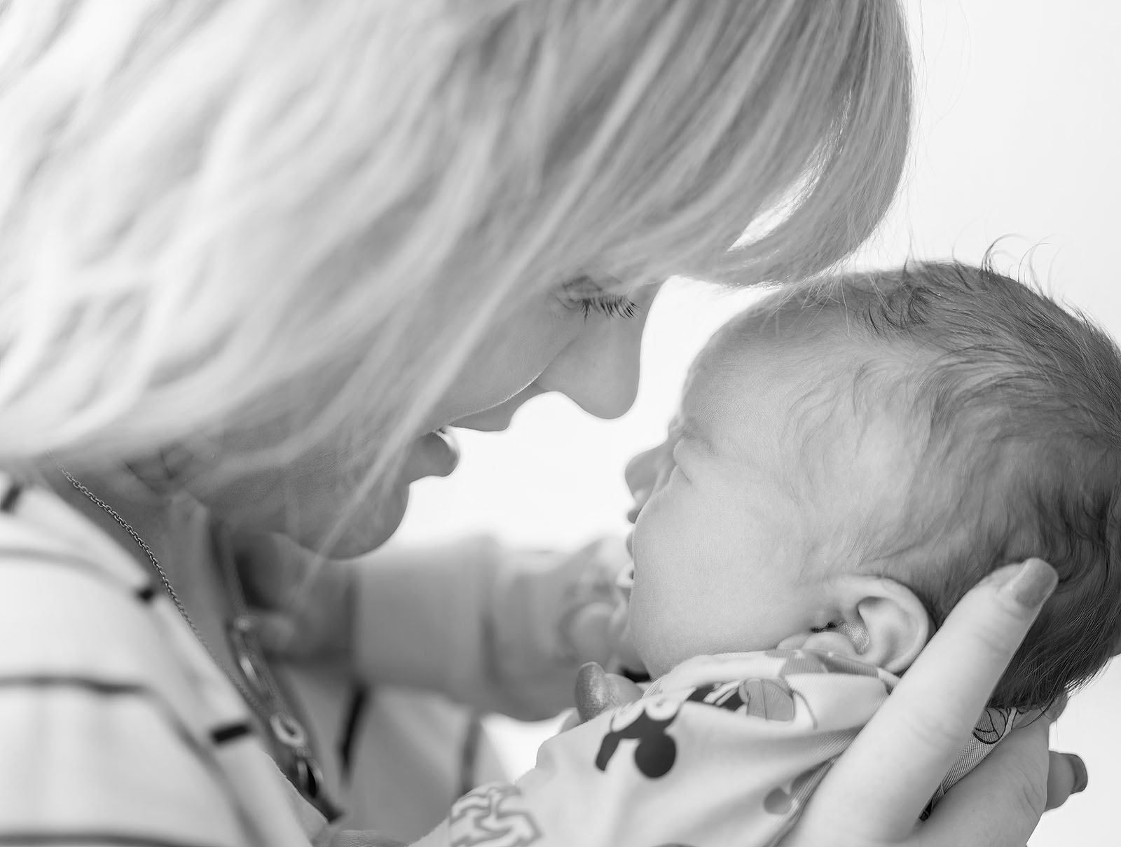 baby walker - flinders medical center newborn photography 10 Mother tenderly cradles sleeping baby, capturing love and warmth in black-and-white photo.