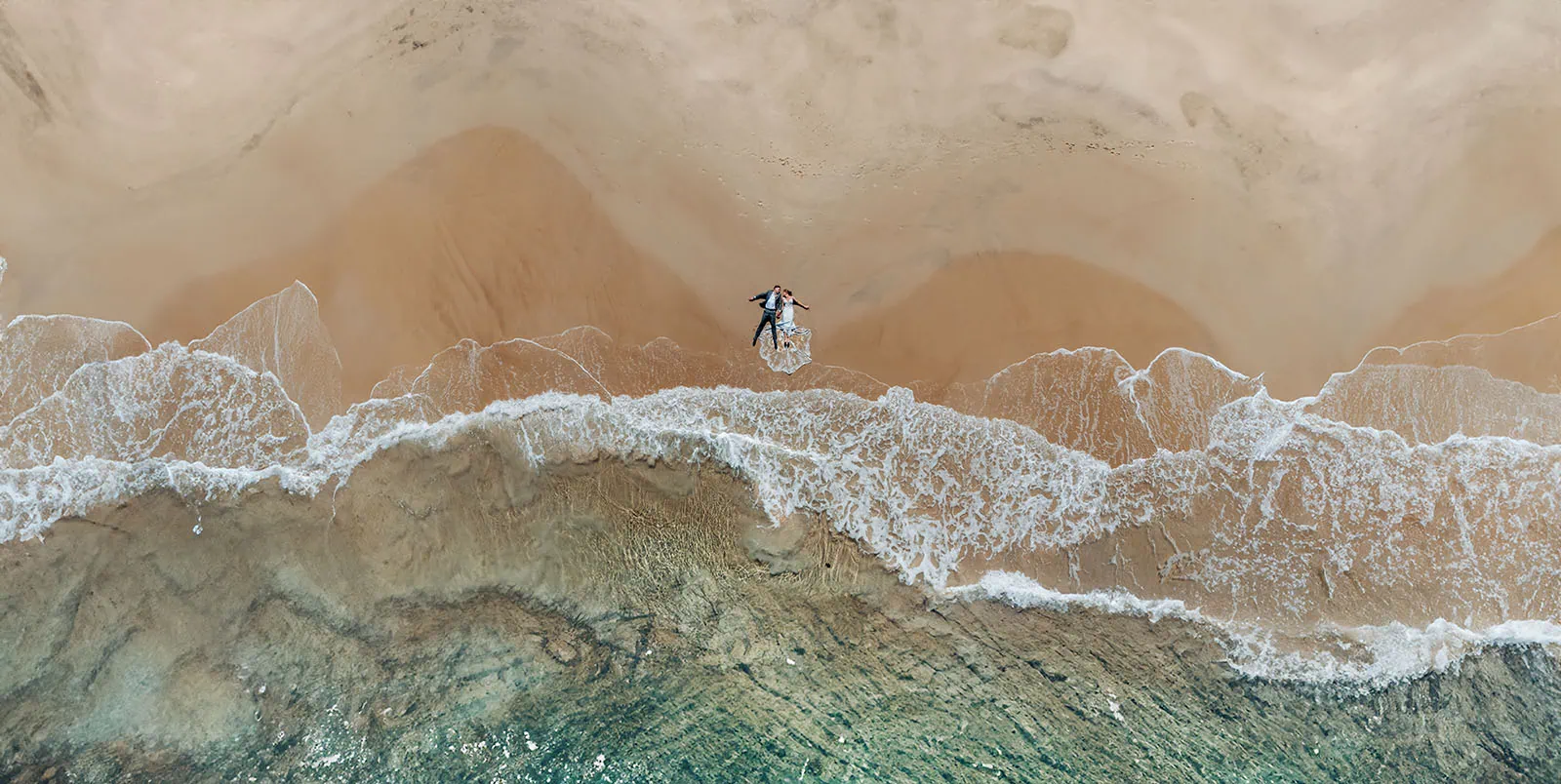 pt noarlunga underwater wreck the dress shoot - jess & jack 7 Aerial view of newlyweds on beach with waves and sandy shoreline.