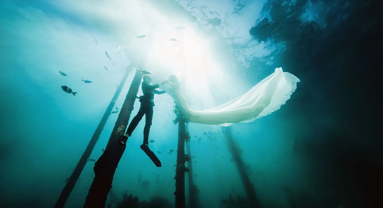 pt noarlunga underwater wreck the dress shoot - jess & jack 16 Underwater couple embracing in formal attire amid serene marine life and structures.