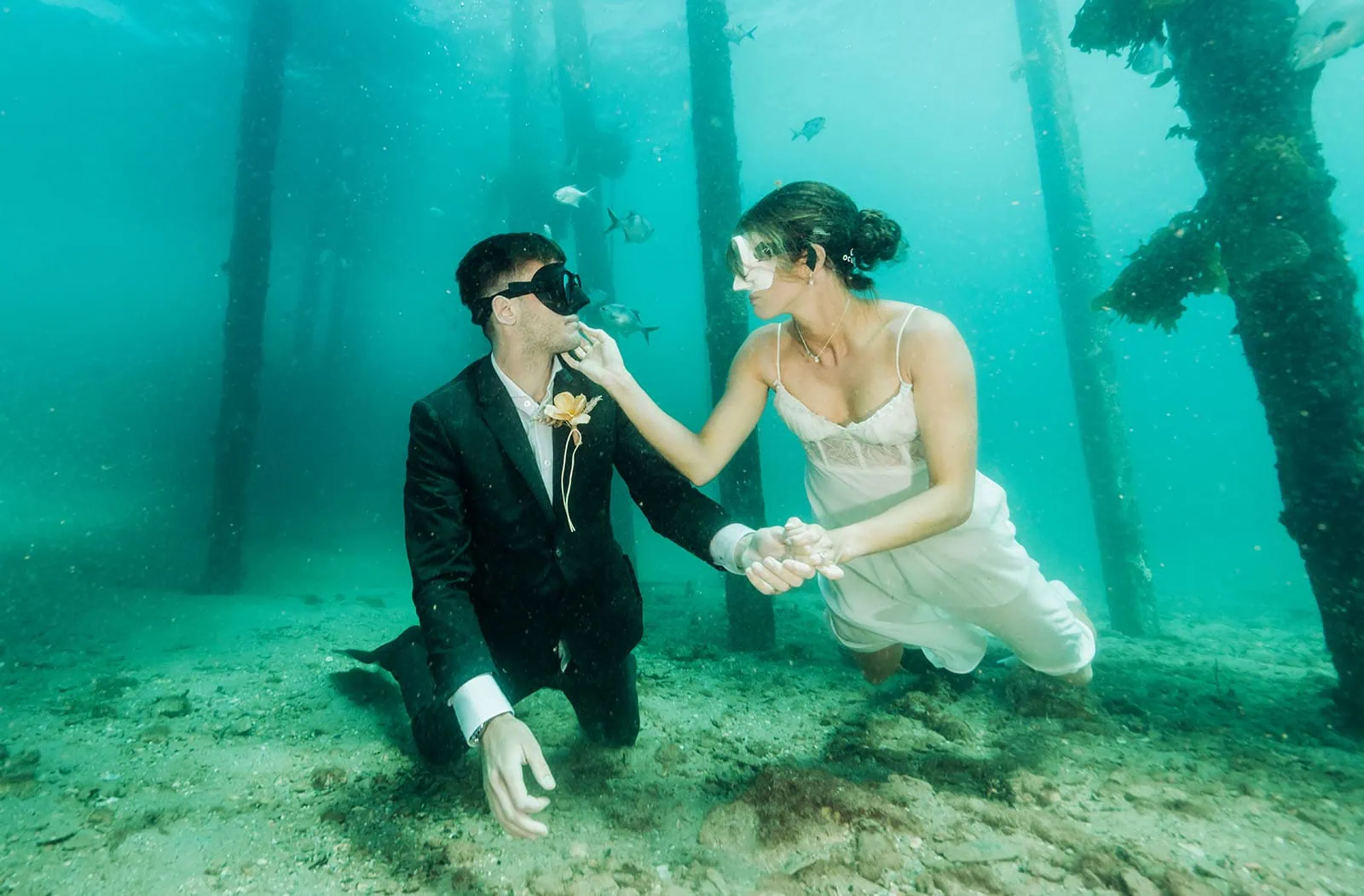 pt noarlunga underwater wreck the dress shoot - jess & jack 18 Underwater couple in formal attire, embracing amid marine life and wooden structures, blends romance and adventure.