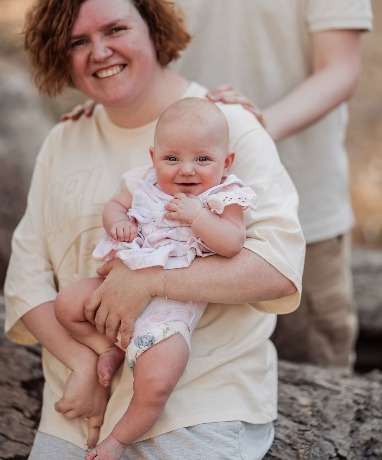 carisbrooke park family photoshoot 71 Joyful family scene: mother and baby outdoors, smiling, in warm sunlight and serene setting.