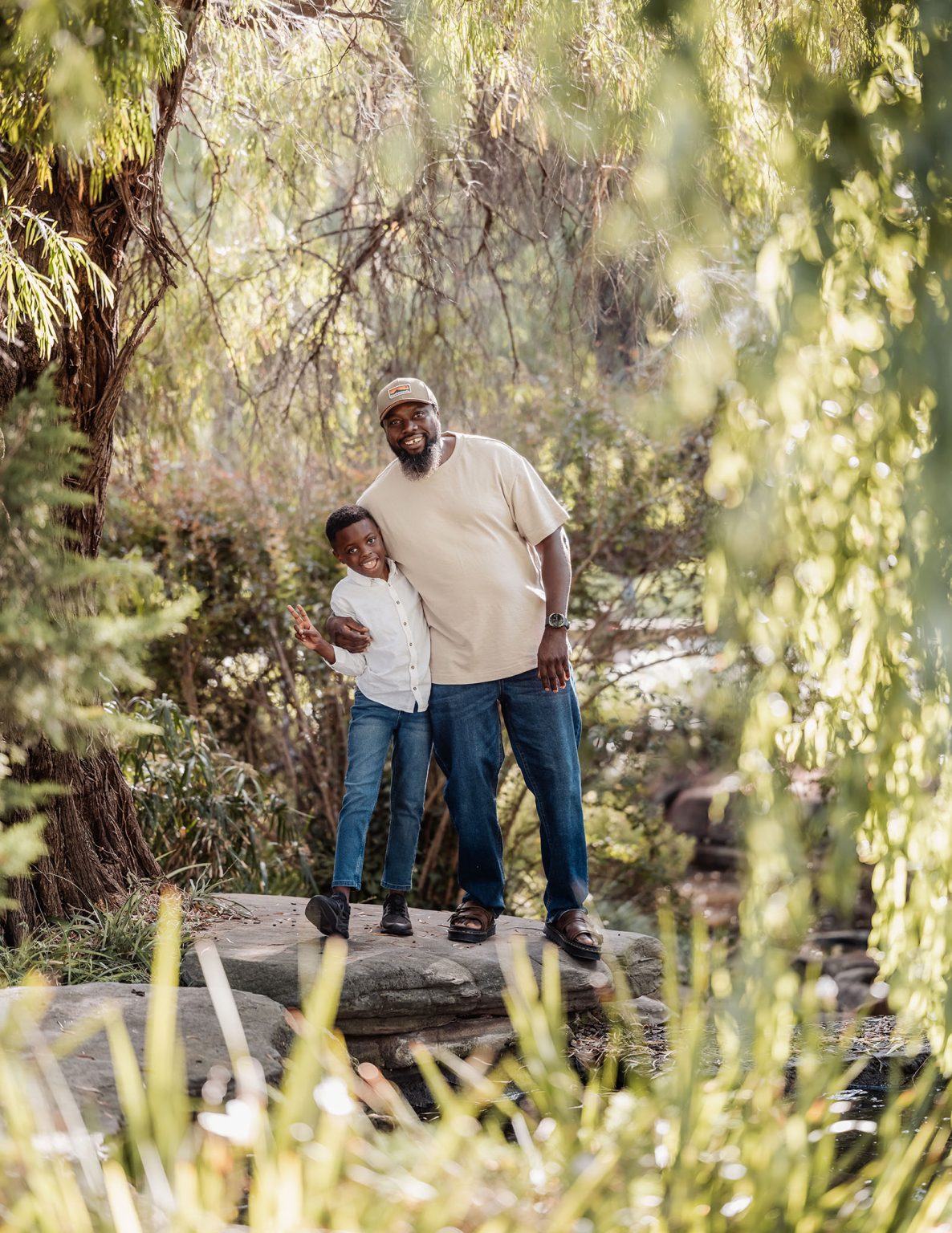 family photoshoot in veale gardens 4 Grandfather and grandson share a joyful bond in serene nature, surrounded by lush greenery.