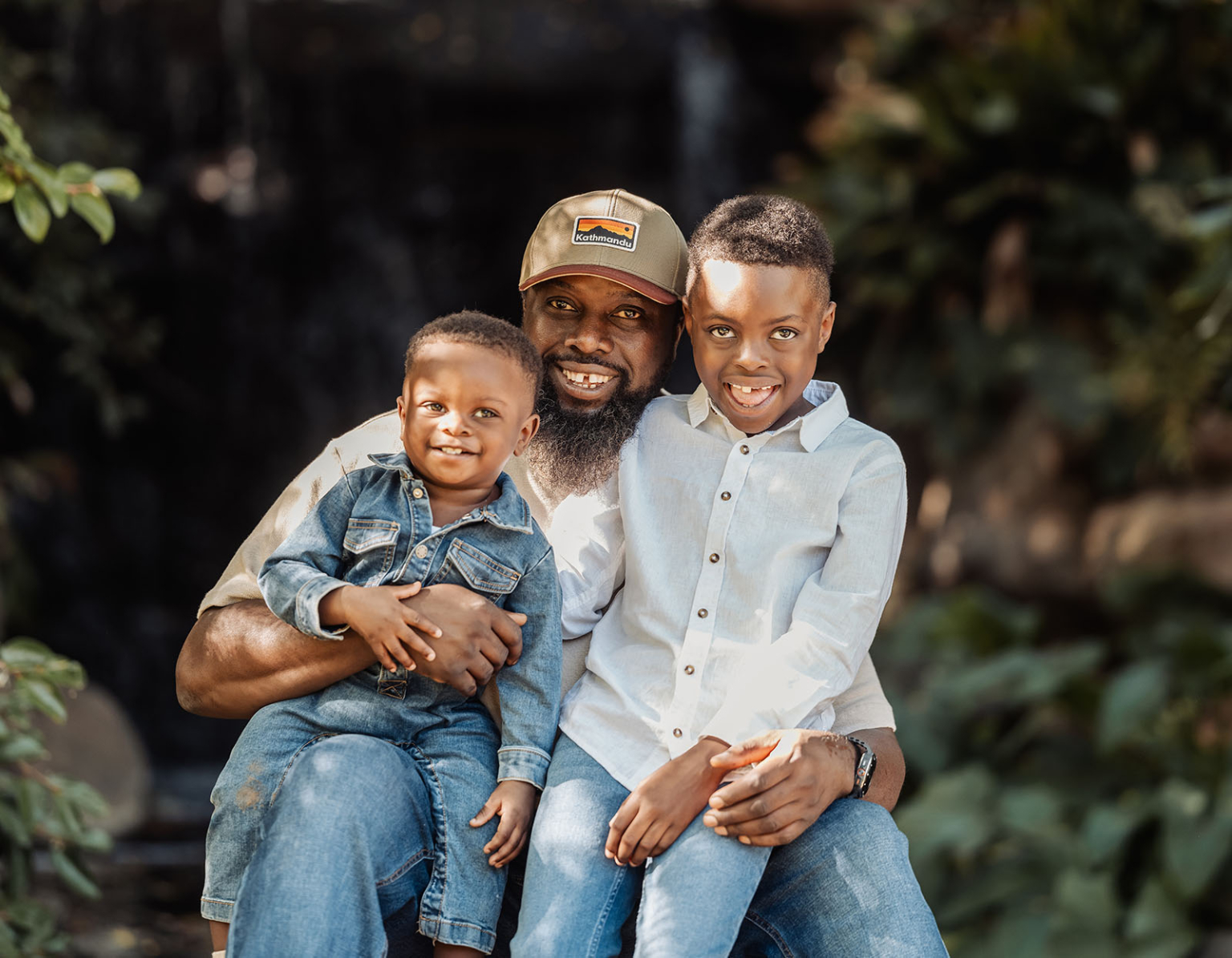 family photoshoot in veale gardens 14 Father with sons in nature, joyful family embrace, denim and white shirts.