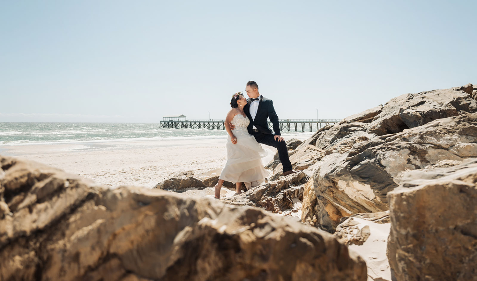 bumbunga lake photoshoot - tina & eric 44 Romantic beach wedding photo: couple in elegant attire, ocean backdrop, sunny sky.