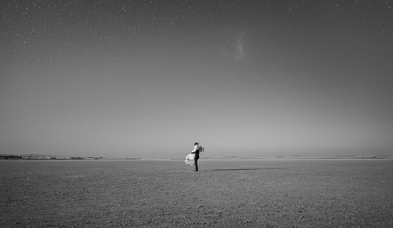 bumbunga lake photoshoot - tina & eric 82 Romantic couple under starry sky in vast, barren landscape.
