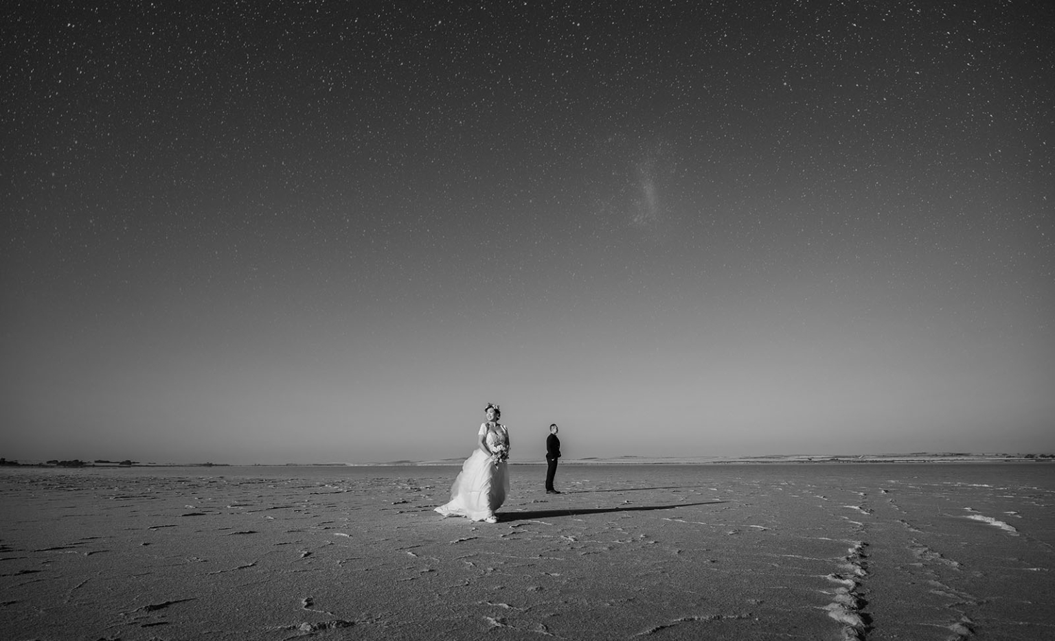 bumbunga lake photoshoot - tina & eric 72 Bridal couple under starry night sky in vast serene landscape.