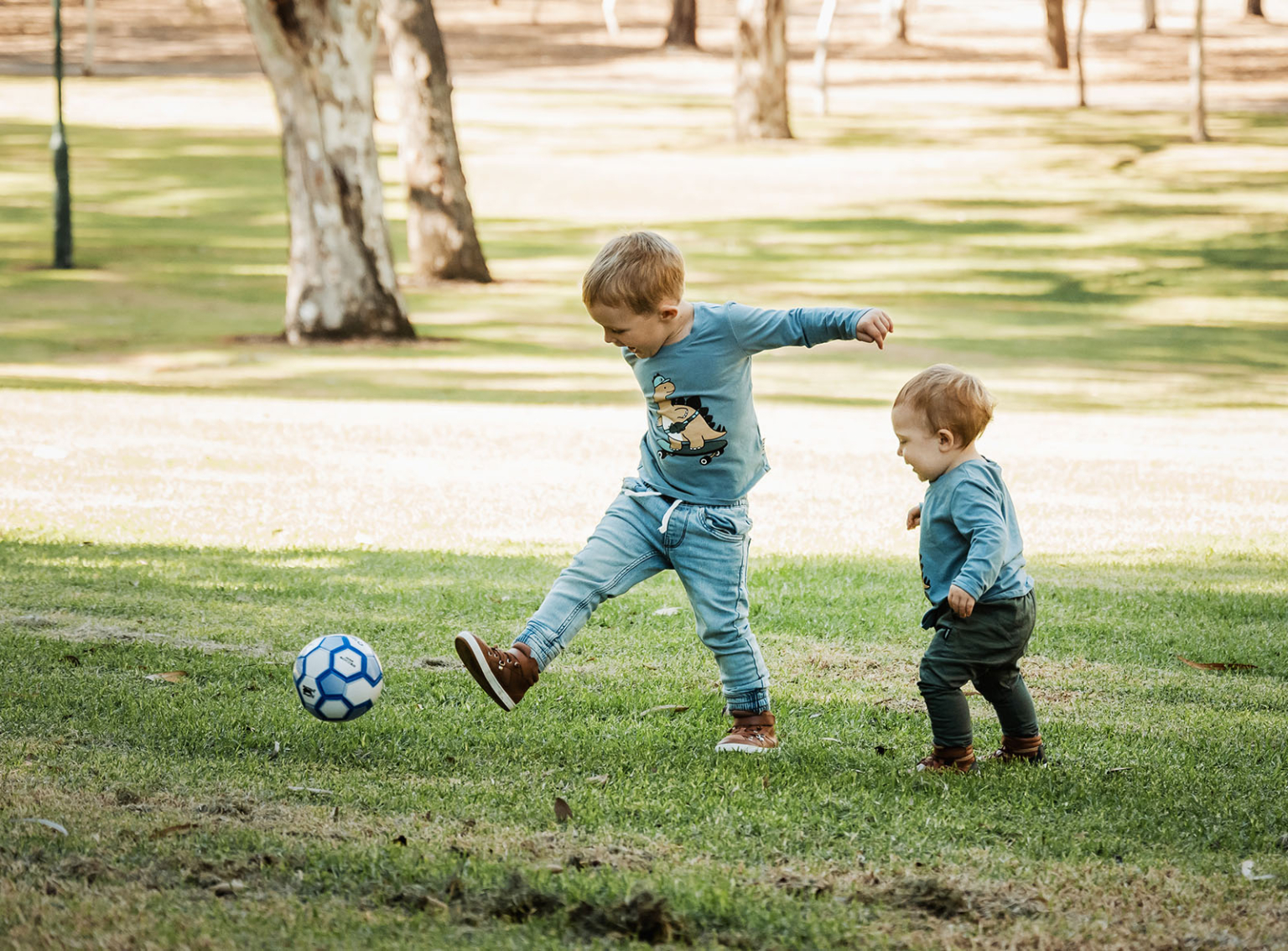 veale gardens family photography 116 Children playing soccer in sunny park, fostering joy, bonding, and outdoor fun.