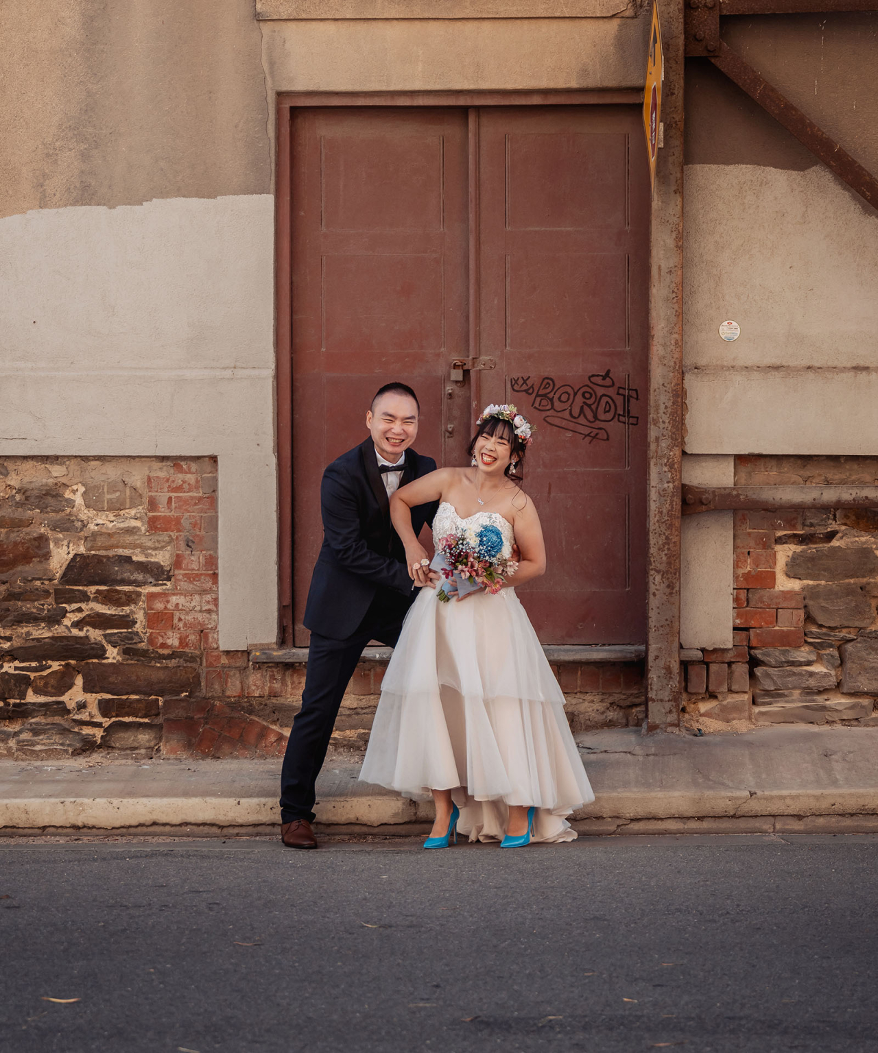 bumbunga lake photoshoot - tina & eric 47 Bride and groom in formal attire against vintage urban backdrop with graffiti.