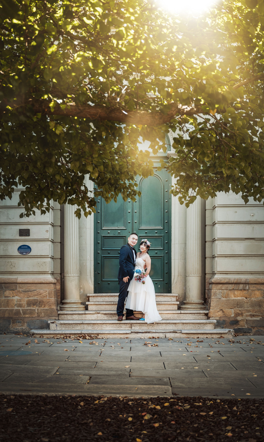 bumbunga lake photoshoot - tina & eric 63 Wedding couple posing romantically on stone steps in front of a grand green European door.