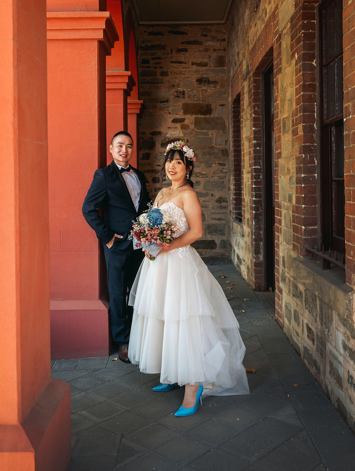 bumbunga lake photoshoot - tina & eric 59 Bride and groom in rustic corridor, wedding elegance with colorful bouquet and floral crown.