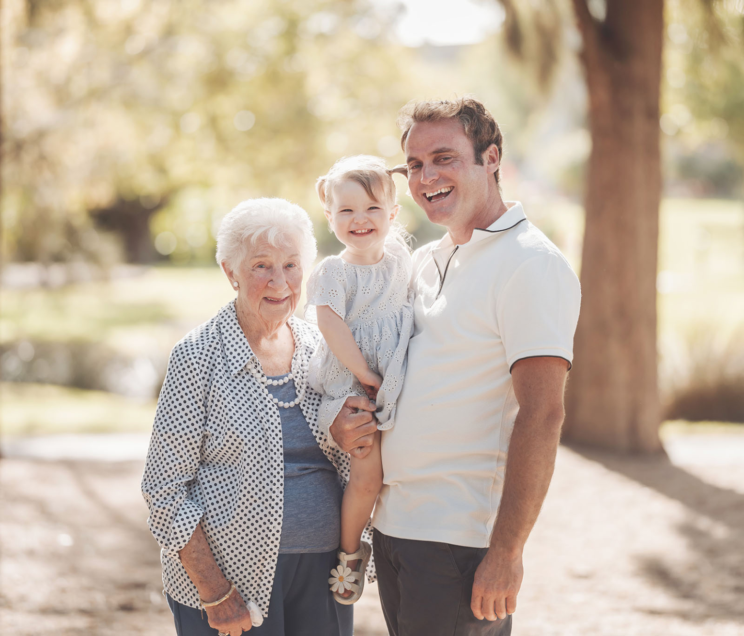 veale gardens family photoshoot 14 Family generations enjoying laughter and bonding outdoors in sunny, lush surroundings.