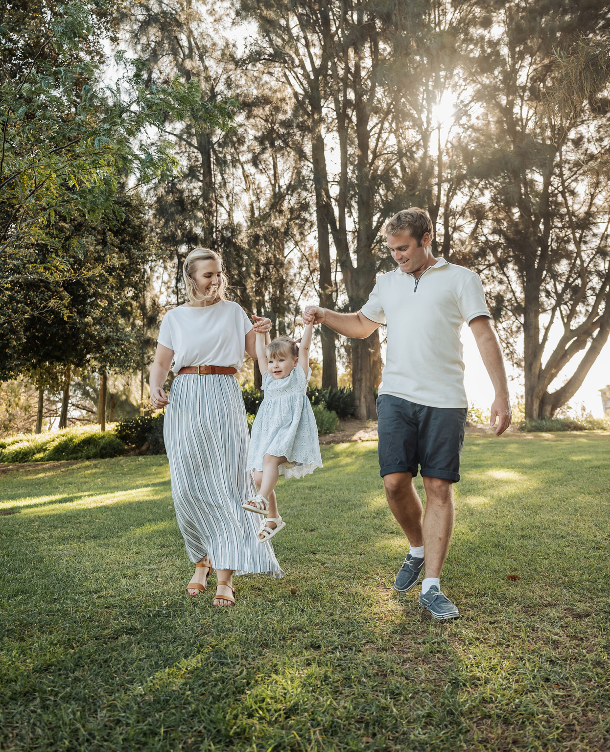 veale gardens family photoshoot 17 Family enjoying playful outdoor moment in park under trees, emphasizing unity and joy.