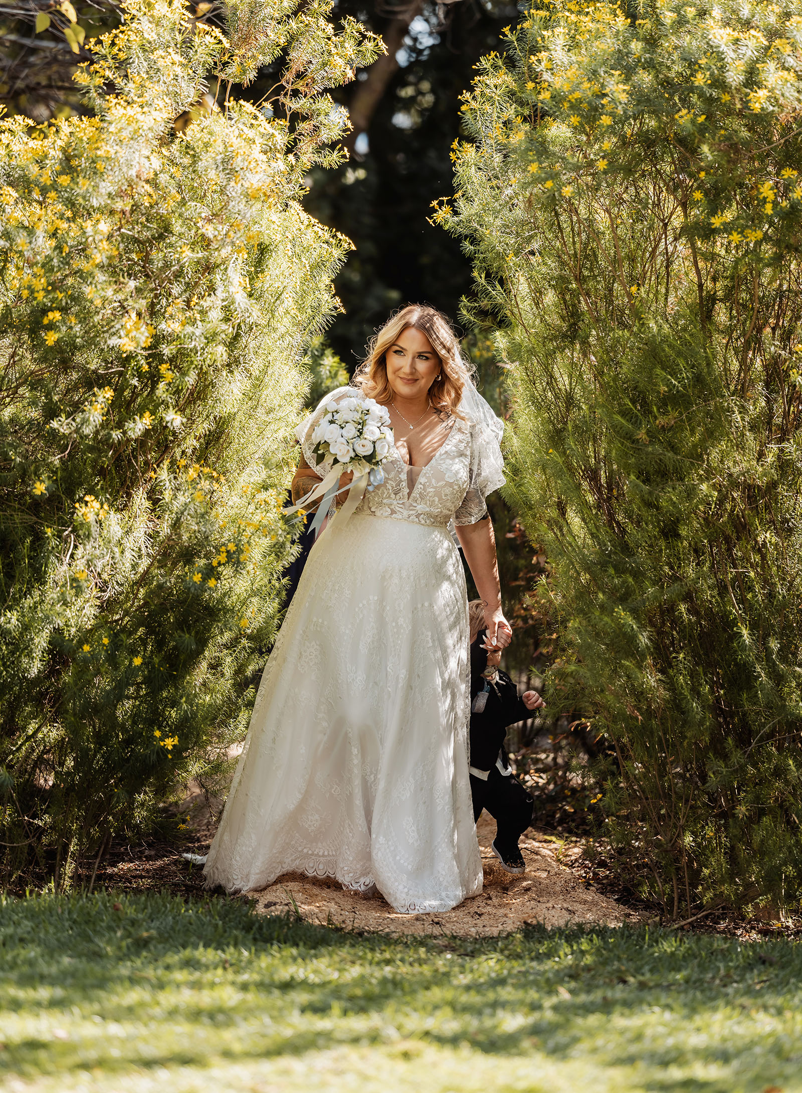 botanic gardens adelaide wedding - melanie & adrian 223 Bride with child in garden, capturing joyful moments.