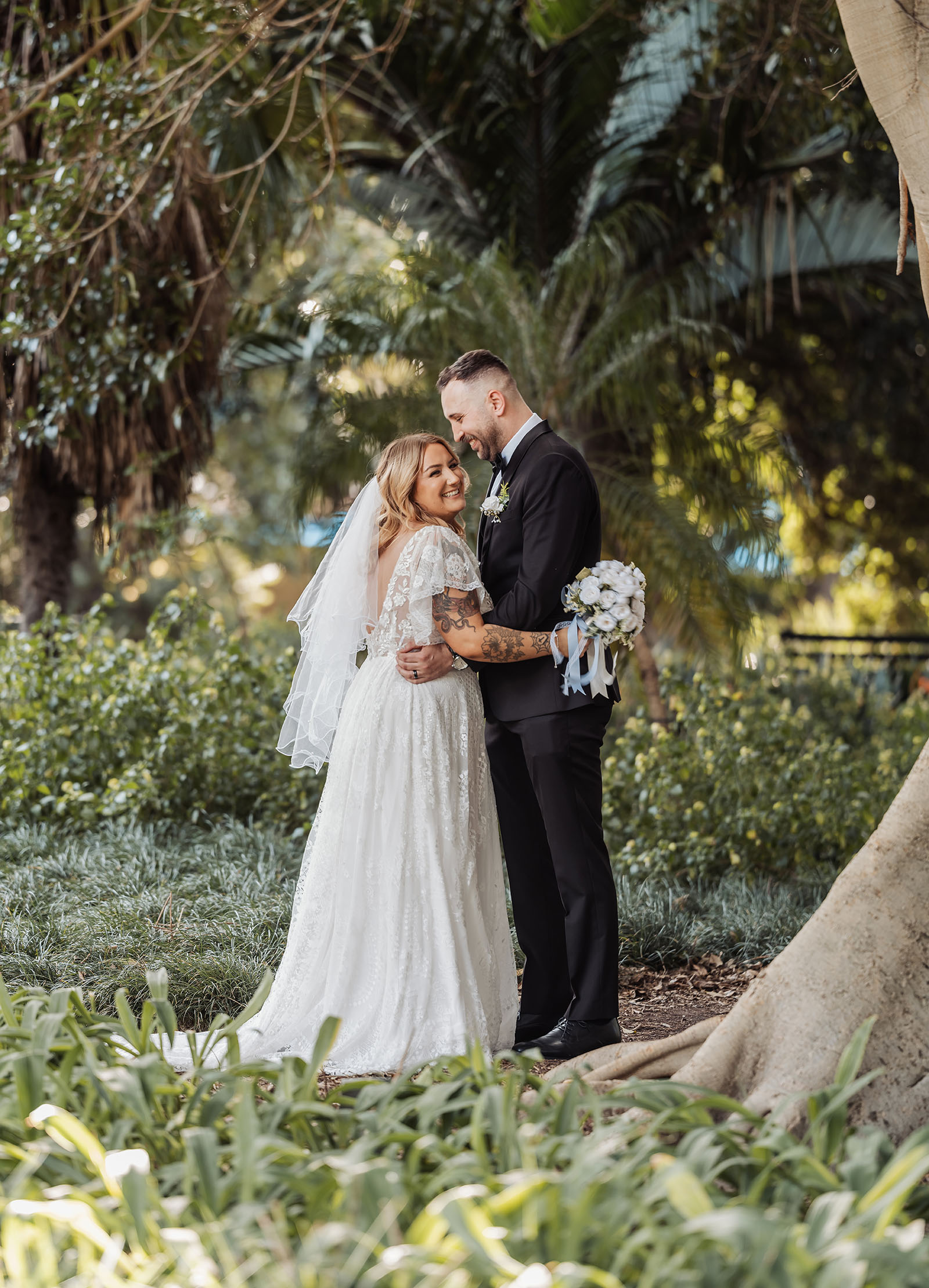 botanic gardens adelaide wedding - melanie & adrian 241 Bride and groom sharing a romantic moment outdoors in scenic setting.