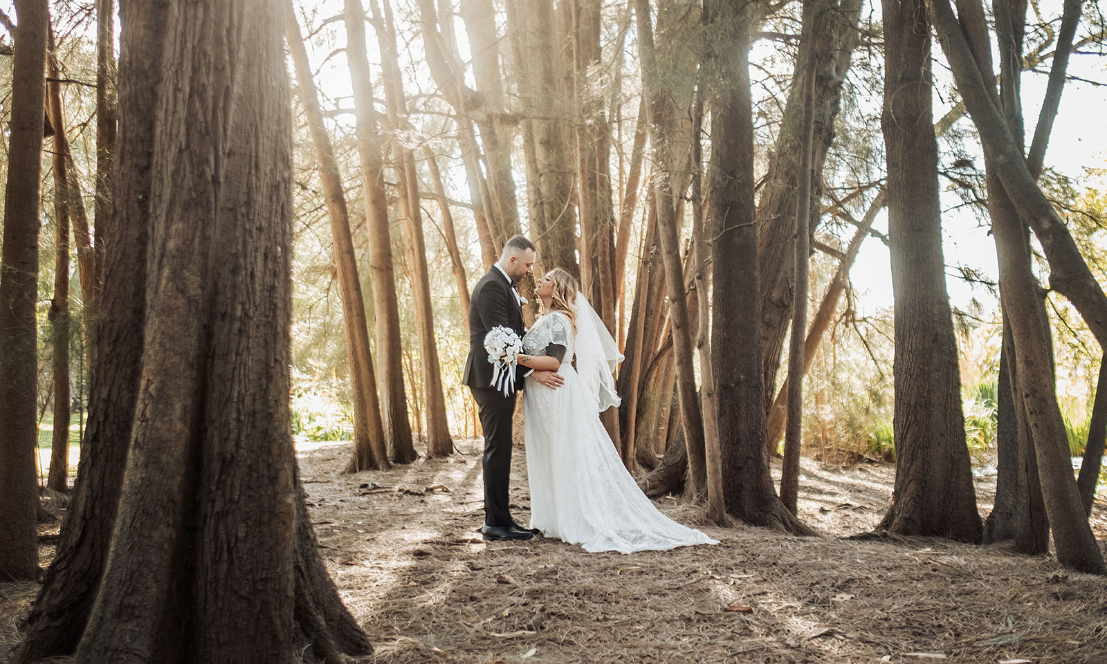 botanic gardens adelaide wedding - melanie & adrian 246 Bride and groom embrace in beautiful forest wedding setting.