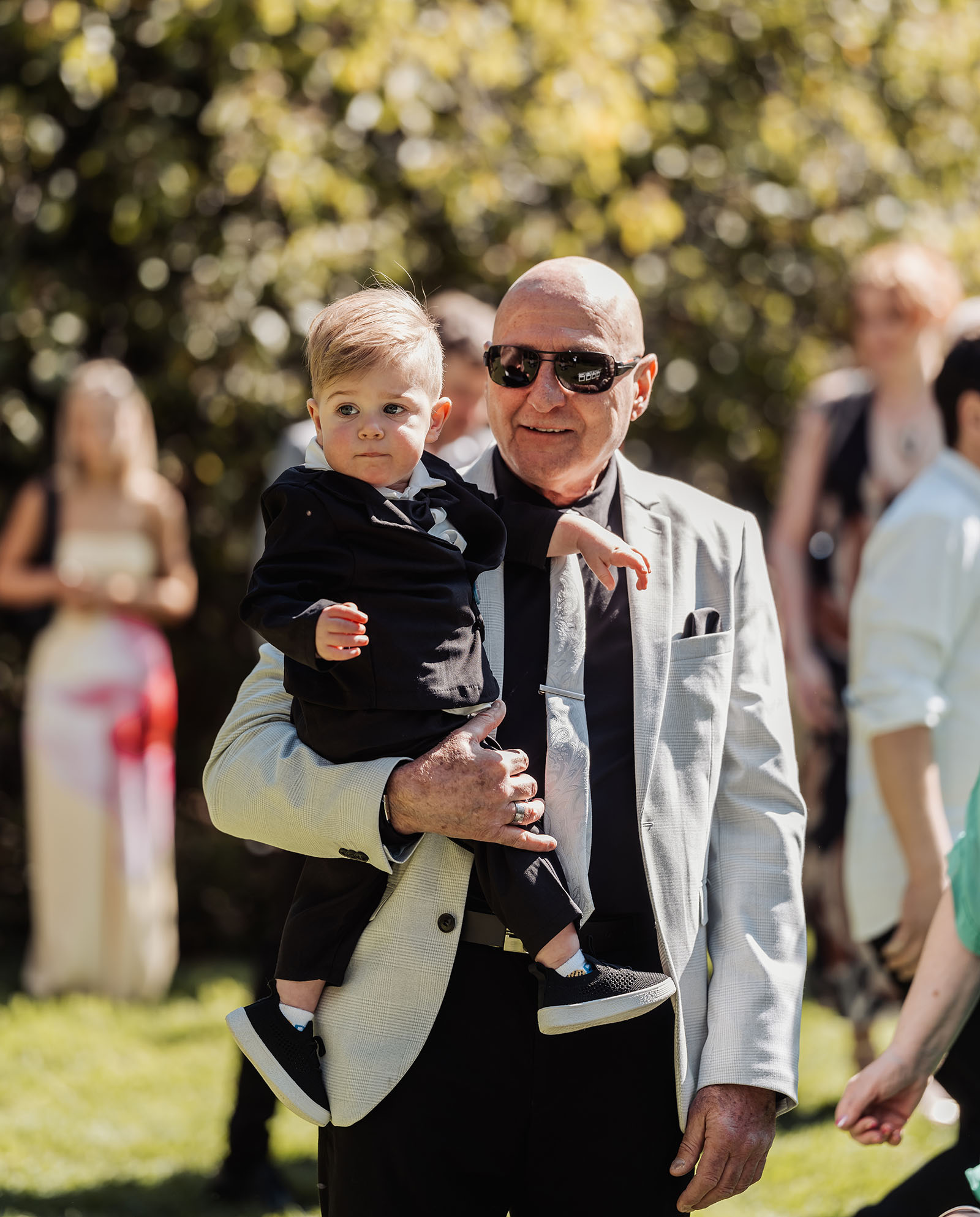 botanic gardens adelaide wedding - melanie & adrian 217 Family in elegant attire posing for a portrait at a formal event.