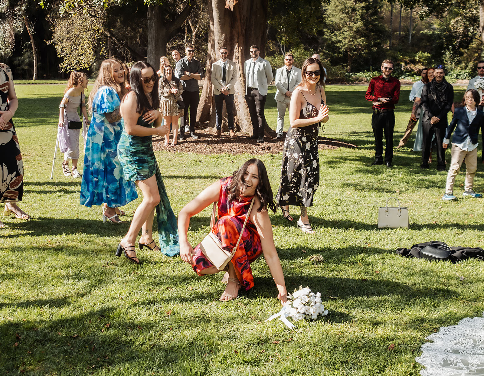 botanic gardens adelaide wedding - melanie & adrian 233 Bride tossing bouquet in vibrant garden setting.