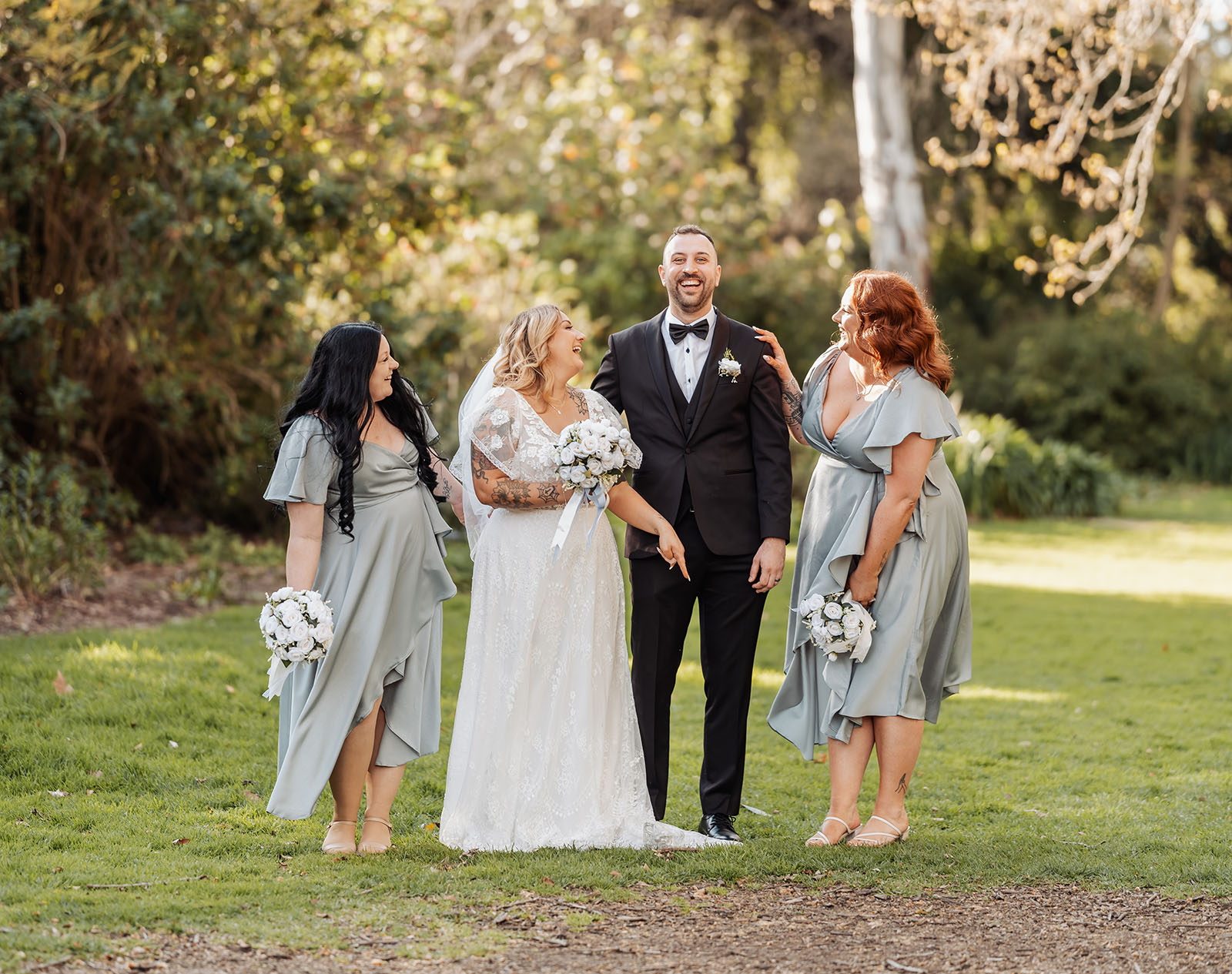 botanic gardens adelaide wedding - melanie & adrian 254 Outdoor wedding celebration with smiling couple and guests under sunny skies.