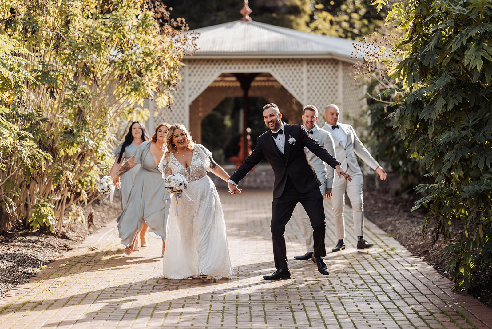 botanic gardens adelaide wedding - melanie & adrian 239 Elegant outdoor wedding ceremony with floral decorations and scenic views.