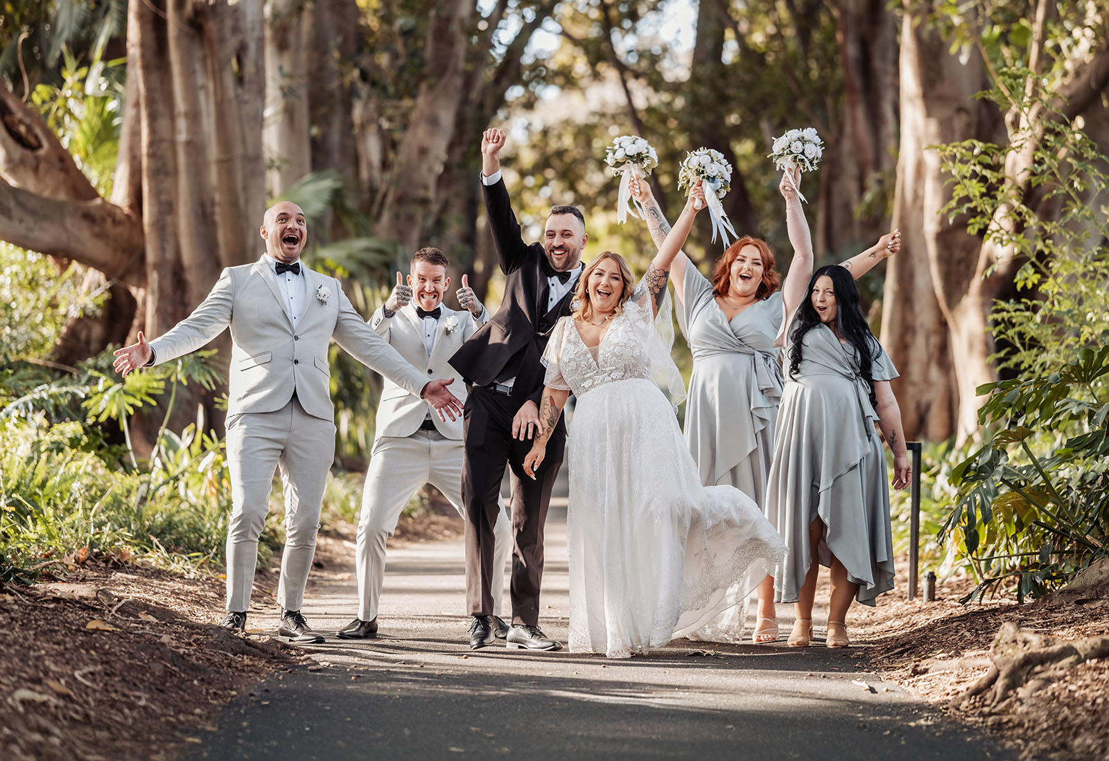 botanic gardens adelaide wedding - melanie & adrian 258 Outdoor wedding celebration with flowers, smiling guests, and sunset backdrop.