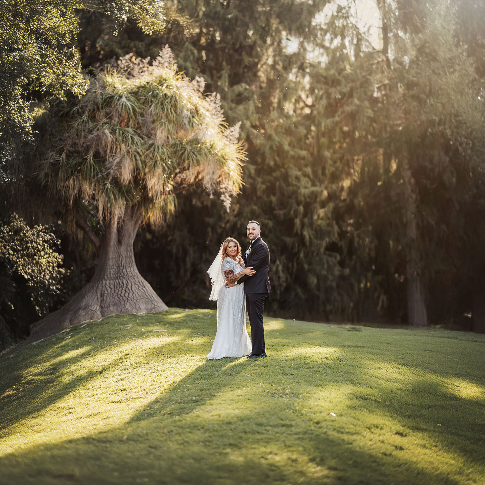 botanic gardens adelaide wedding - melanie & adrian 251 Bride and groom smiling on green lawn at outdoor wedding ceremony.