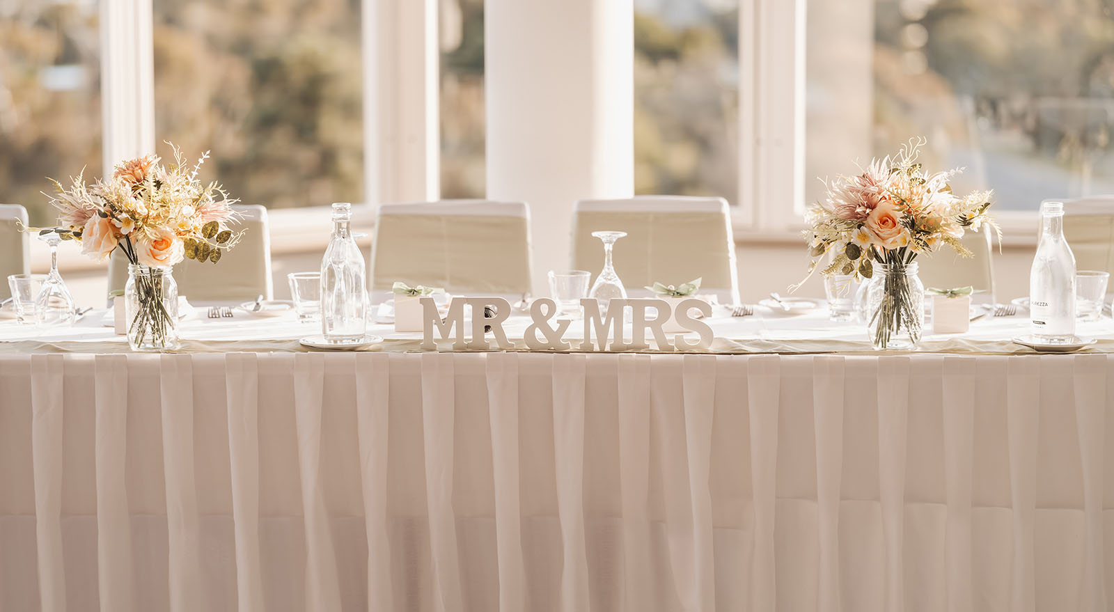 botanic gardens adelaide wedding - melanie & adrian 264 Elegant wedding reception table with floral centerpieces, white linens, and candlelight ambiance.