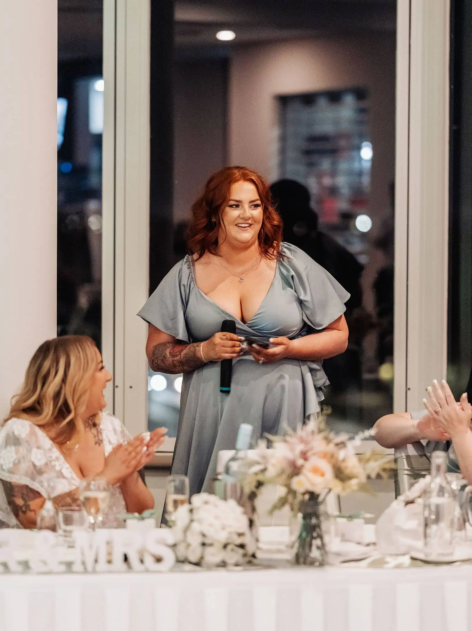 botanic gardens adelaide wedding - melanie & adrian 277 Wedding speech highlights joyful celebration, guests cheering, toasting bride and groom in elegant venue.