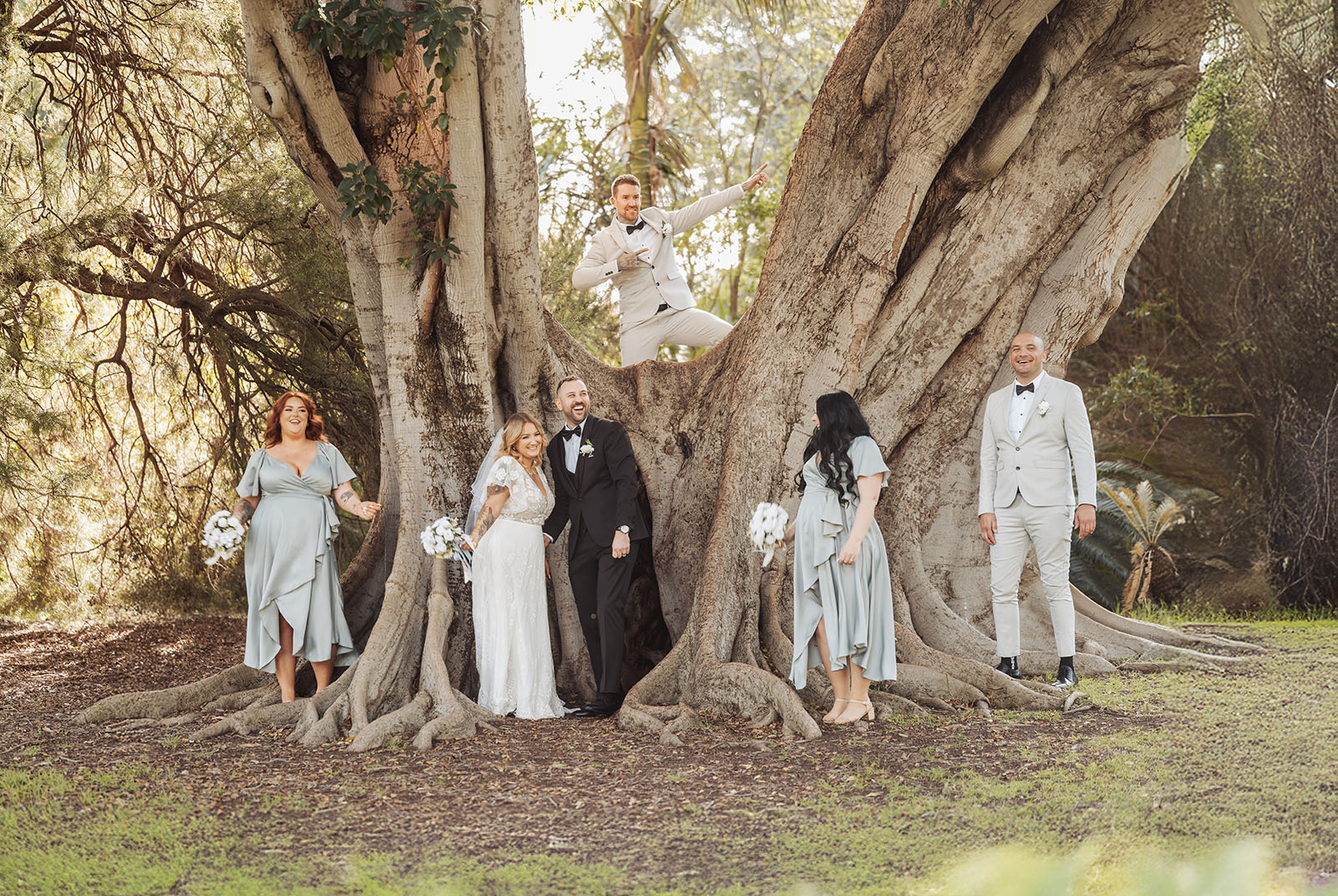 botanic gardens adelaide wedding - melanie & adrian 243 Bride and groom exchange vows under a sprawling, picturesque tree.