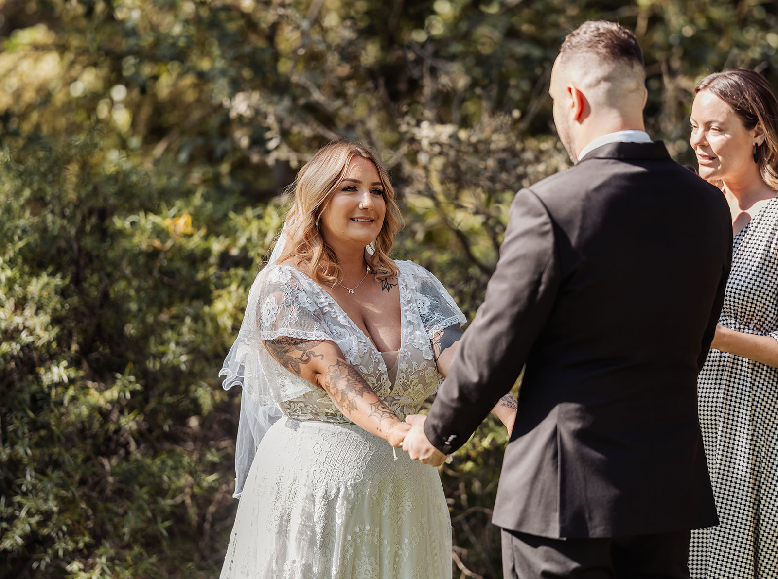botanic gardens adelaide wedding - melanie & adrian 225 Garden wedding ceremony with couple exchanging vows under floral arch.