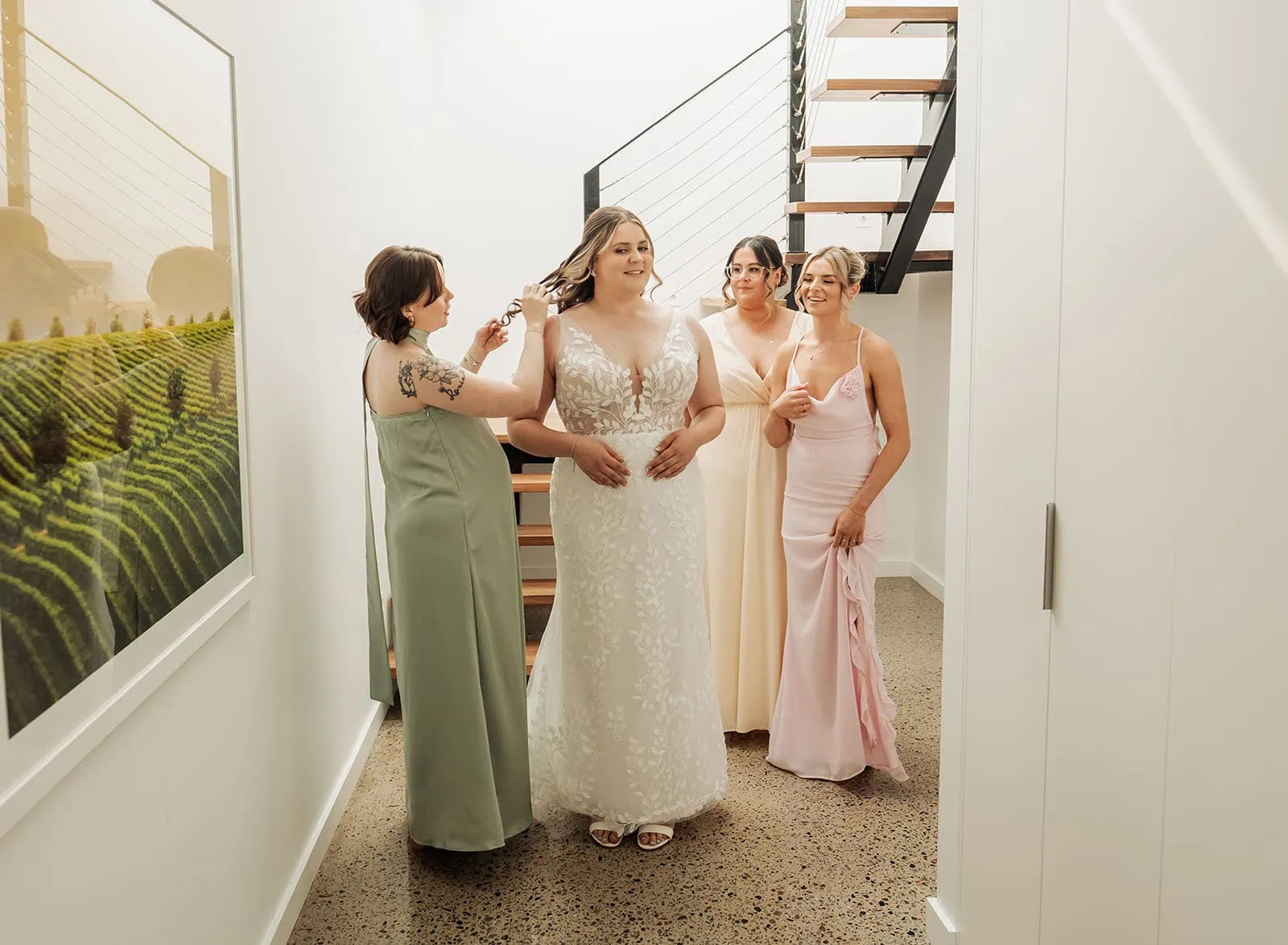 beach rd wines wedding - hana & jessie 45 Bridal party preparing together in elegant dresses, sharing joyful moments.