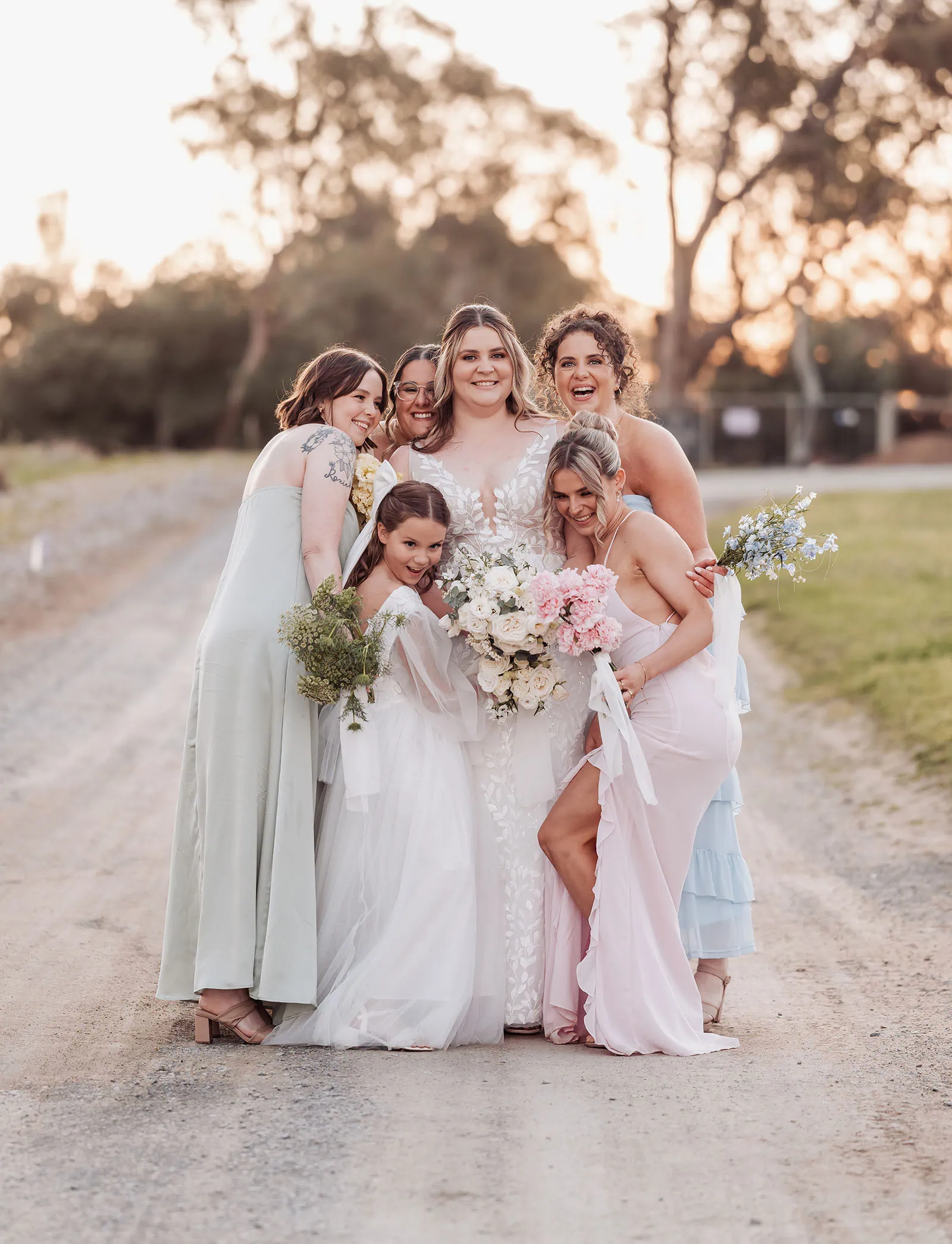 beach rd wines wedding - hana & jessie 83 Bride and bridesmaids celebrate at sunset in elegant dresses.