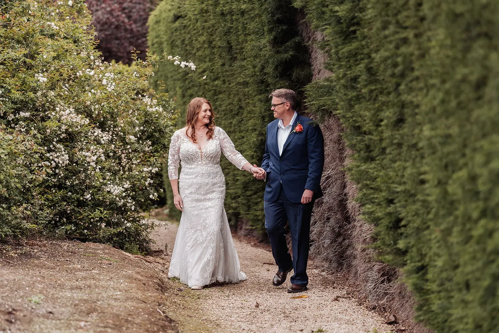 carrick hill wedding - jo & david 278 Bride and groom walking down a picturesque garden path.