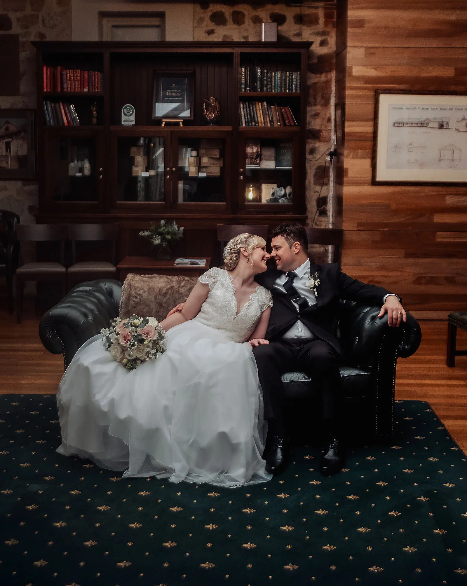 mt lofty house elopement - kimberley & michael 194 Bride and groom relax on a sofa in a cozy room.