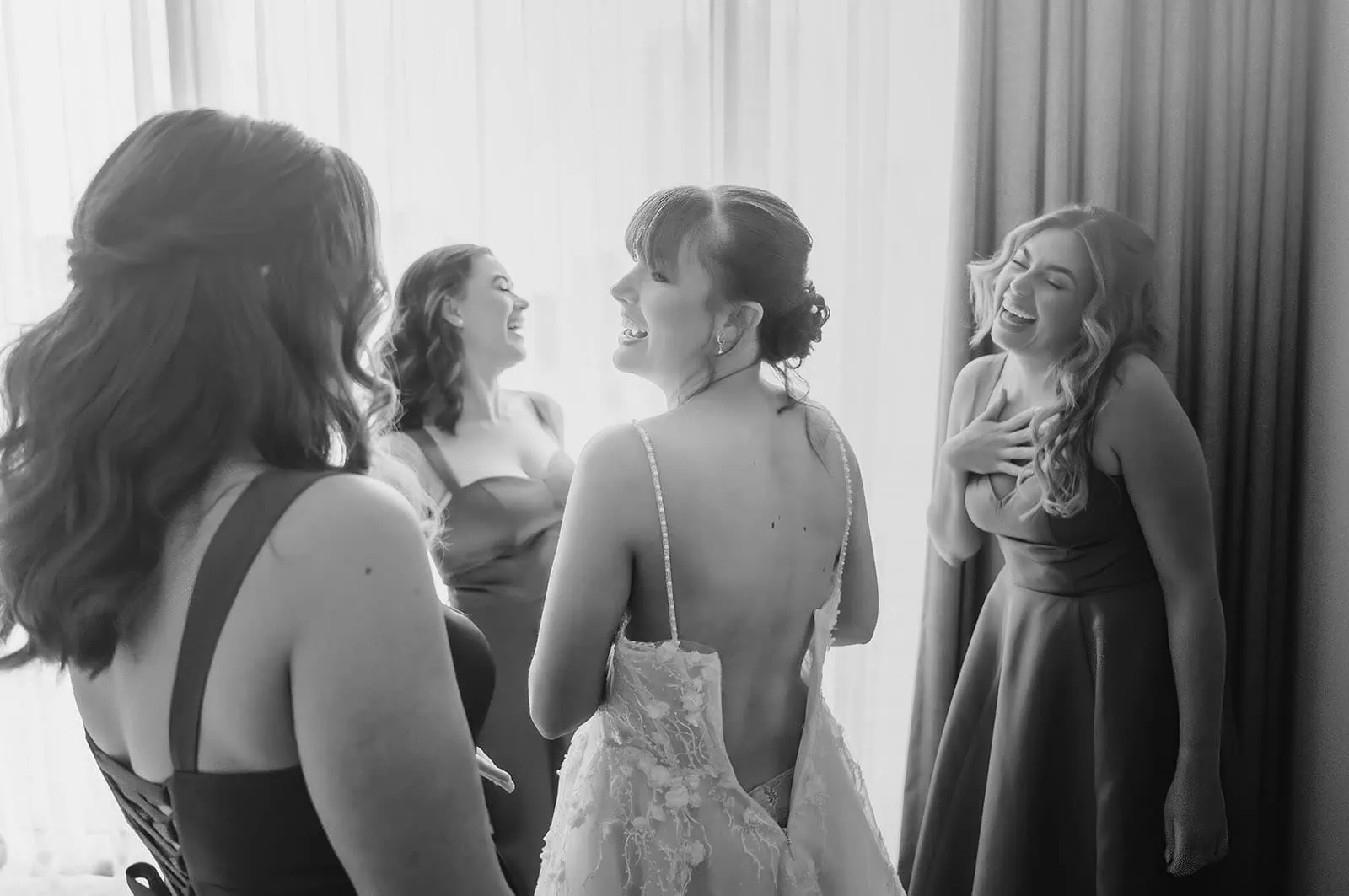 adelaide botanic gardens summerhouse wedding - belinda & ian 145 Bride surrounded by smiling bridesmaids in matching dresses at wedding ceremony.