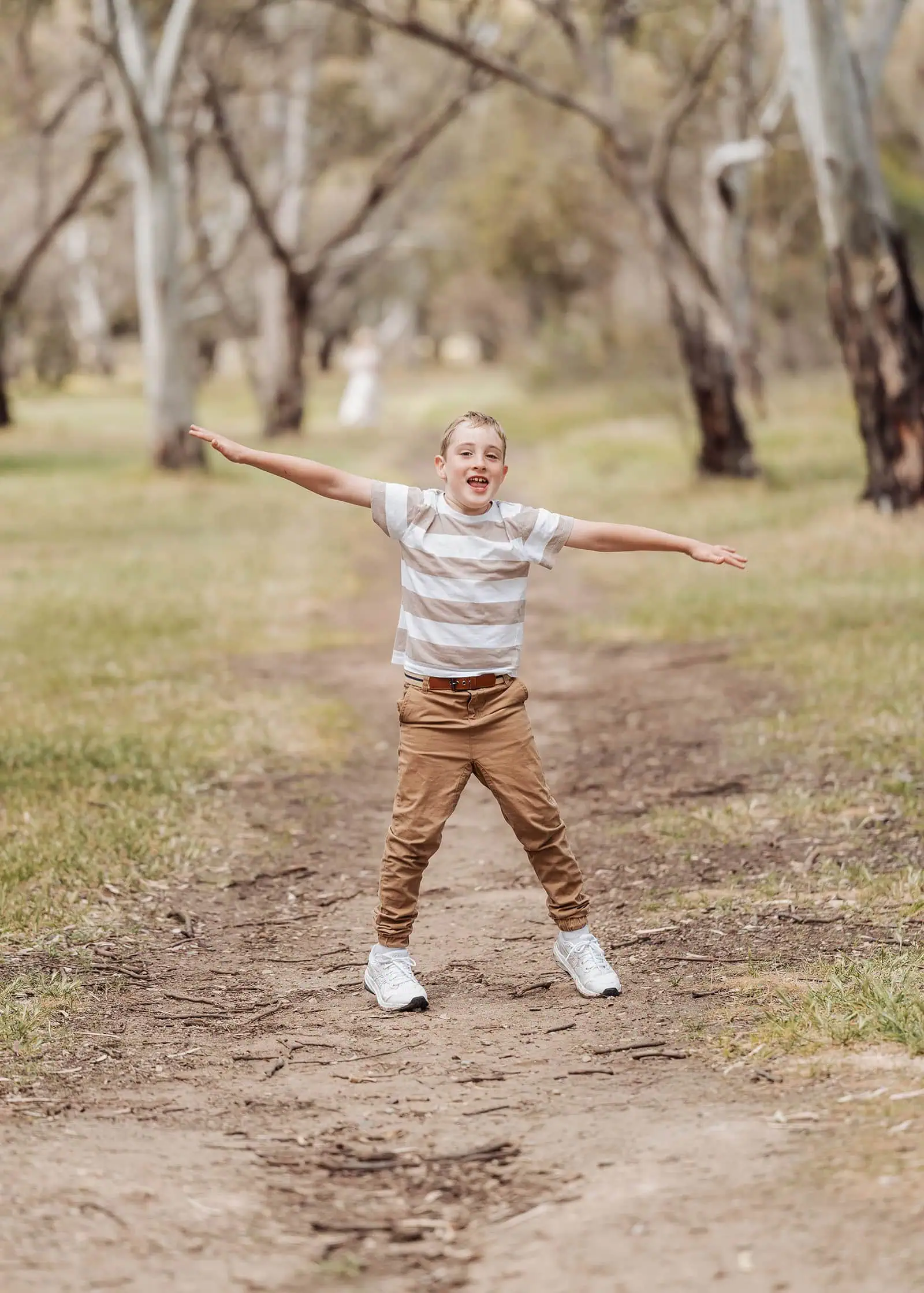 southern parklands family photography 43 Child exploring a serene forest landscape, surrounded by lush greenery and sunlight.