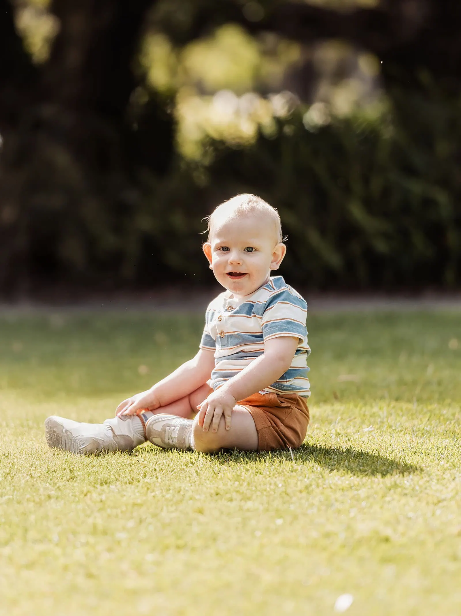 southern parklands family photography 35 Child playing outdoors on green lawn under sunny sky.
