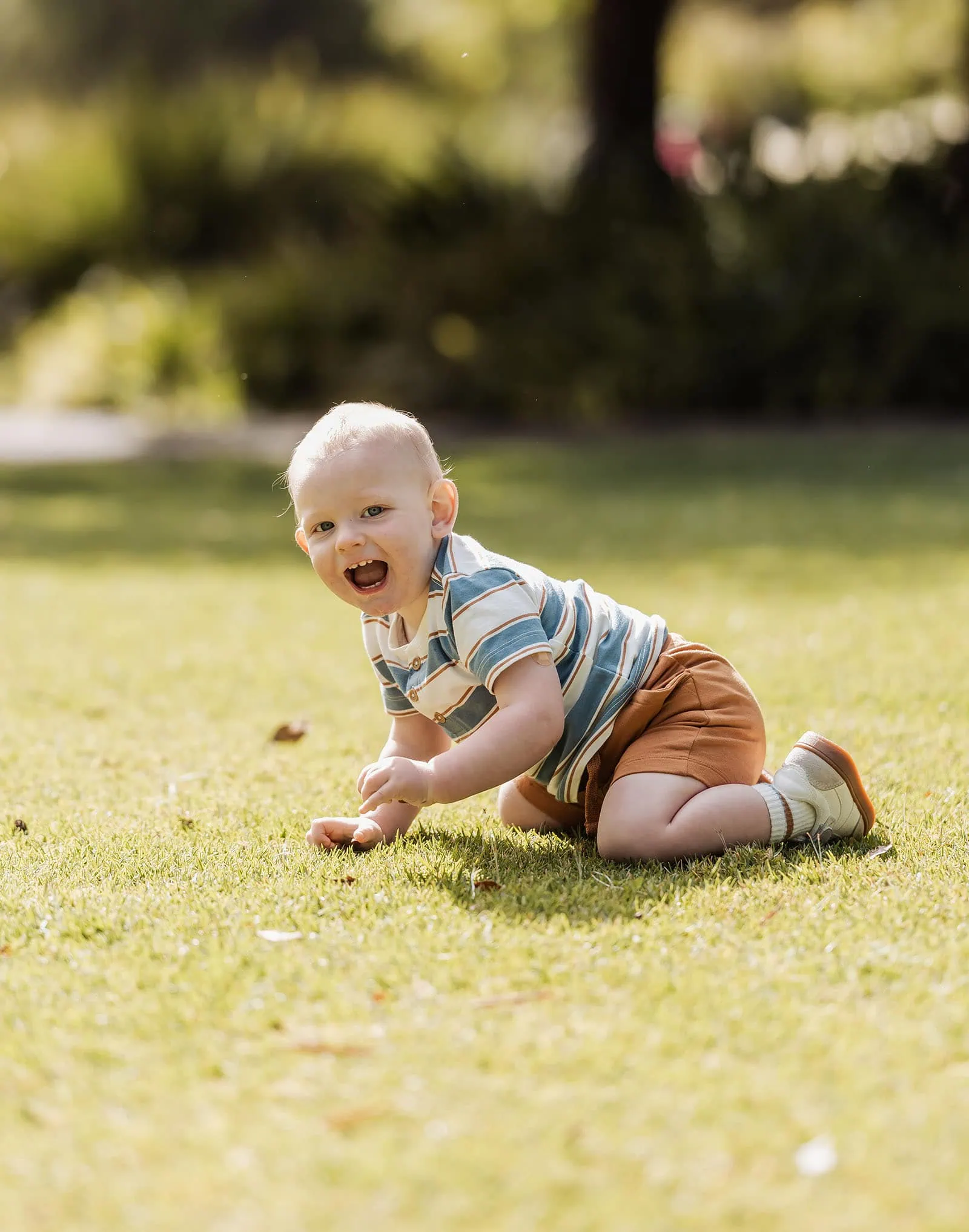 southern parklands family photography 36 Child playing joyfully outdoors on green grass.