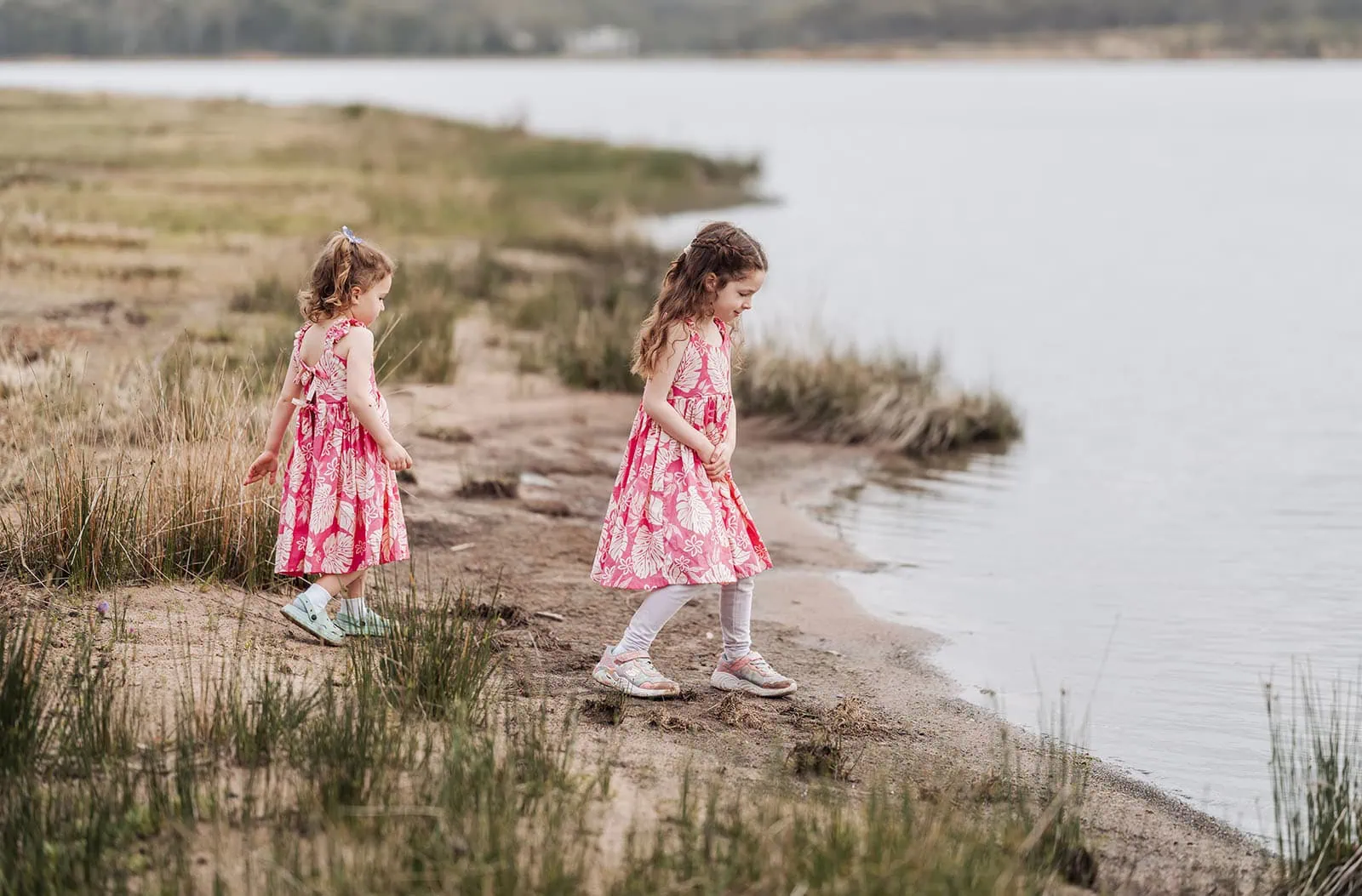happy valley reservoir family photoshoot 11 Children playing by the water, wearing pink outfits and enjoying a sunny day.