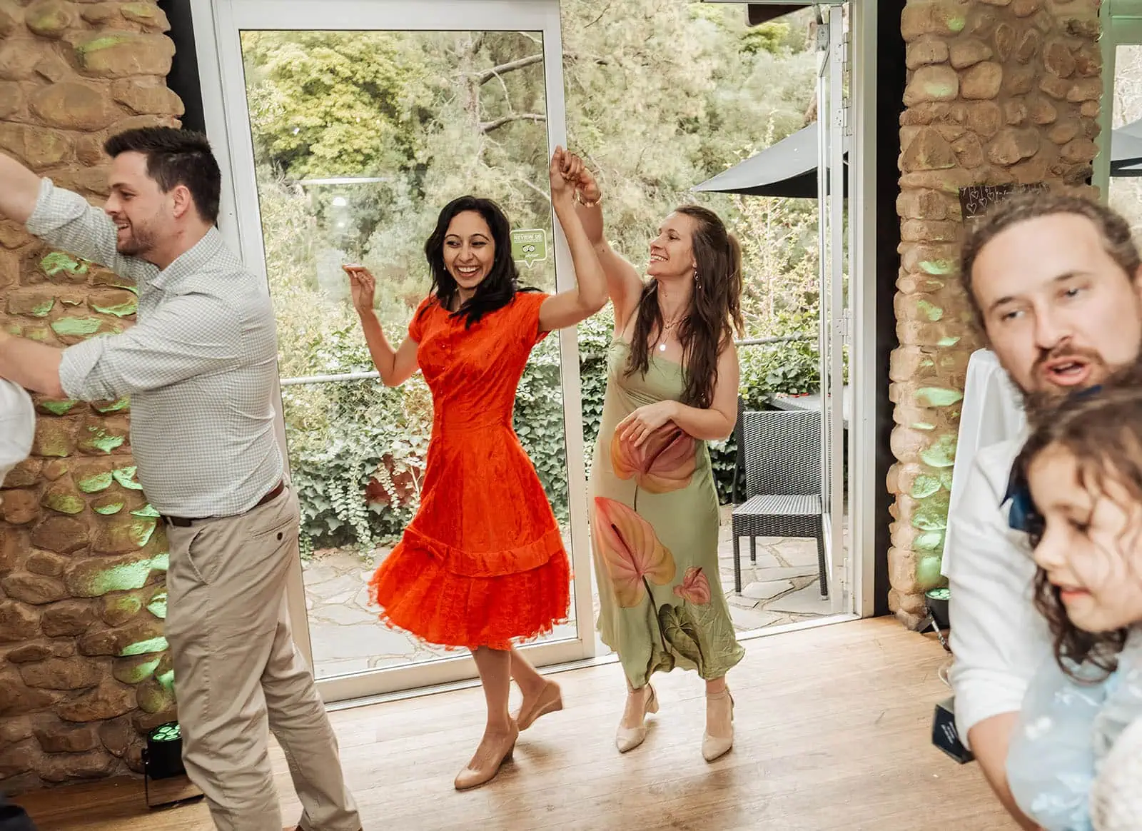 utopia waterfall gully wedding - sally & ben 265 Joyful group dancing outdoors at festival celebration, vibrant energy and colorful outfits.