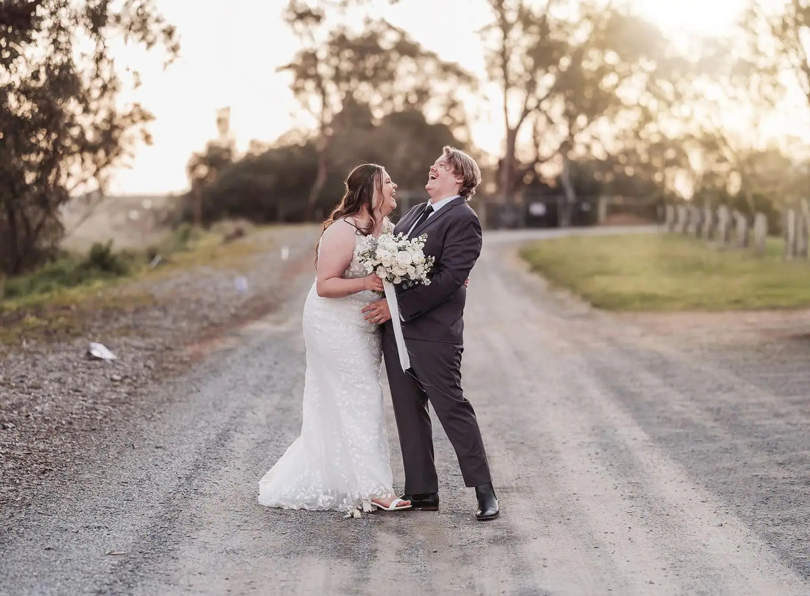 beach rd wines wedding - hana & jessie 86 Elegant couple in wedding attire smiling warmly outdoors.
