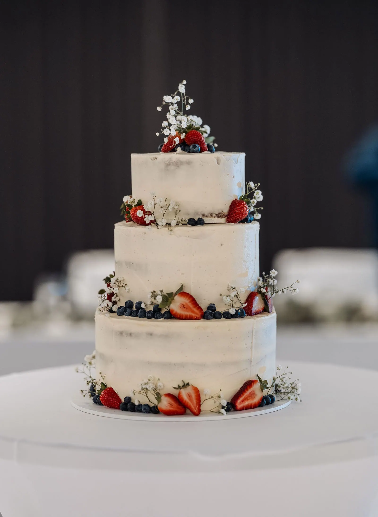 adelaide botanic gardens summerhouse wedding - belinda & ian 200 Elegant three-tier cake adorned with fresh berries and delicate frosting.